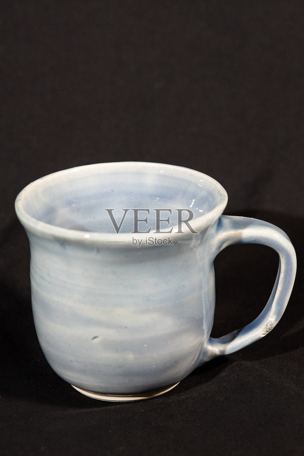 垂直拍摄的一个美丽的手工杯子在一个黑暗的背景照片摄影图片