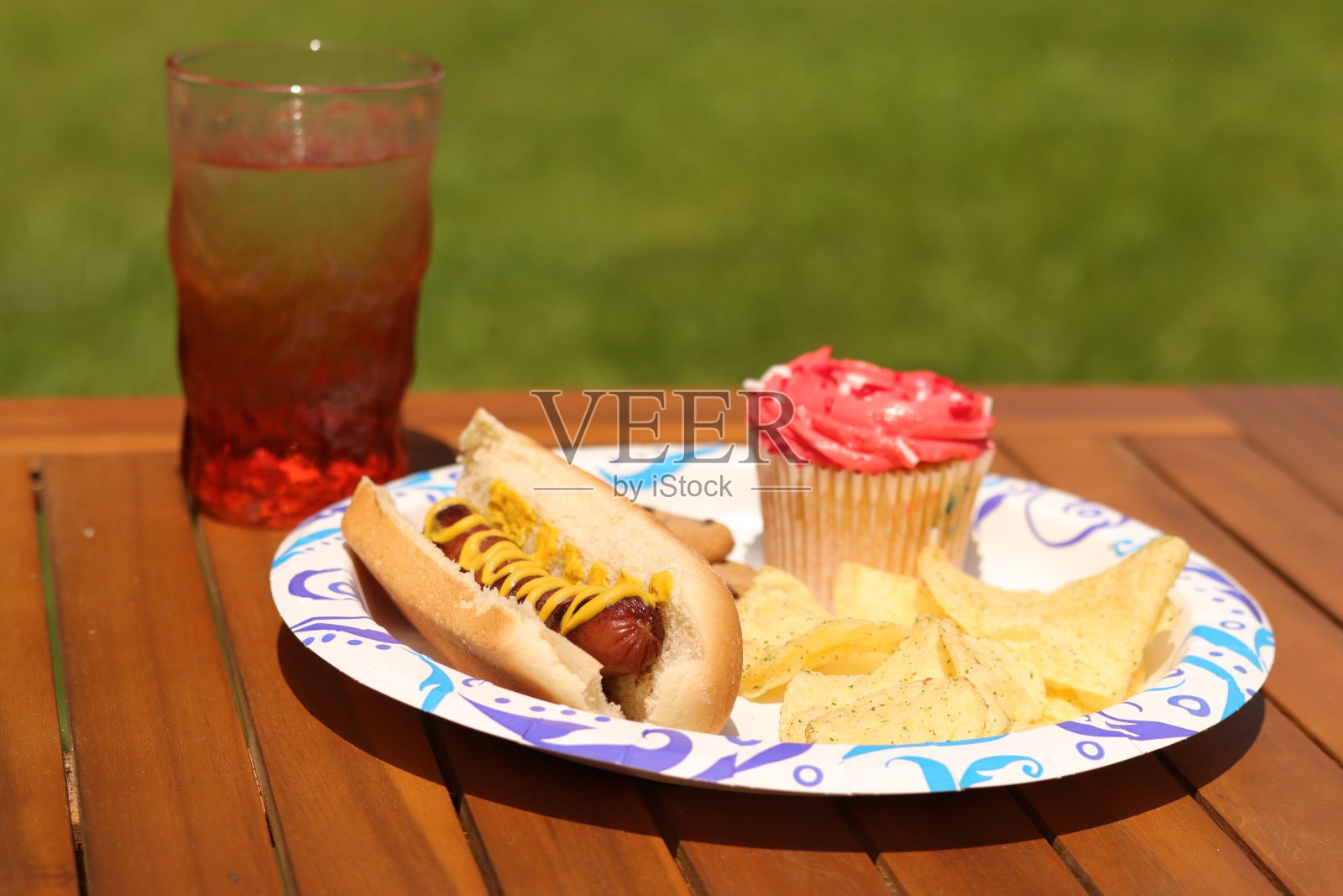 野餐盘里有热狗,小蛋糕和饮料照片摄影图片