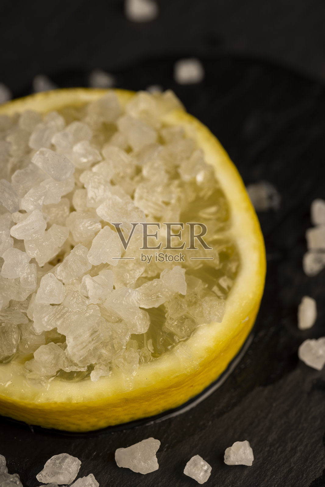 成熟的黄柠檬和盐放在黑板上照片摄影图片