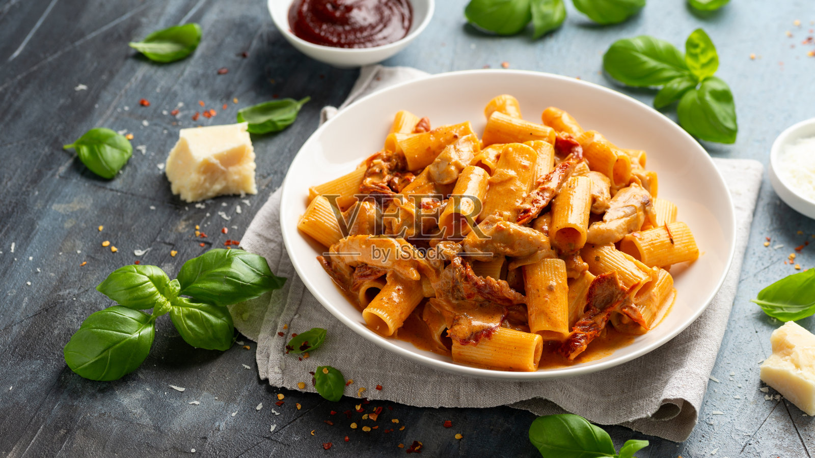 辣酱面配鸡肉,番茄干和羊乳干酪。照片摄影图片