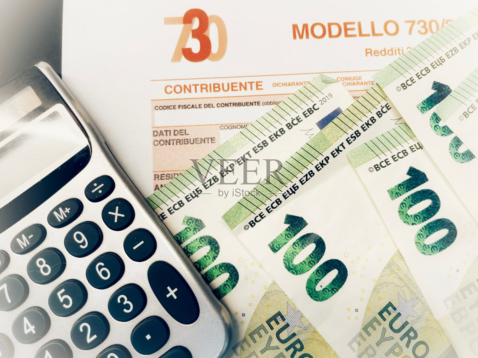 佛罗伦萨省,2024年1月14日,许多欧元纸币以Modello 730为背景,用意大利语翻译为收入申报,纳税概念。照片摄影图片