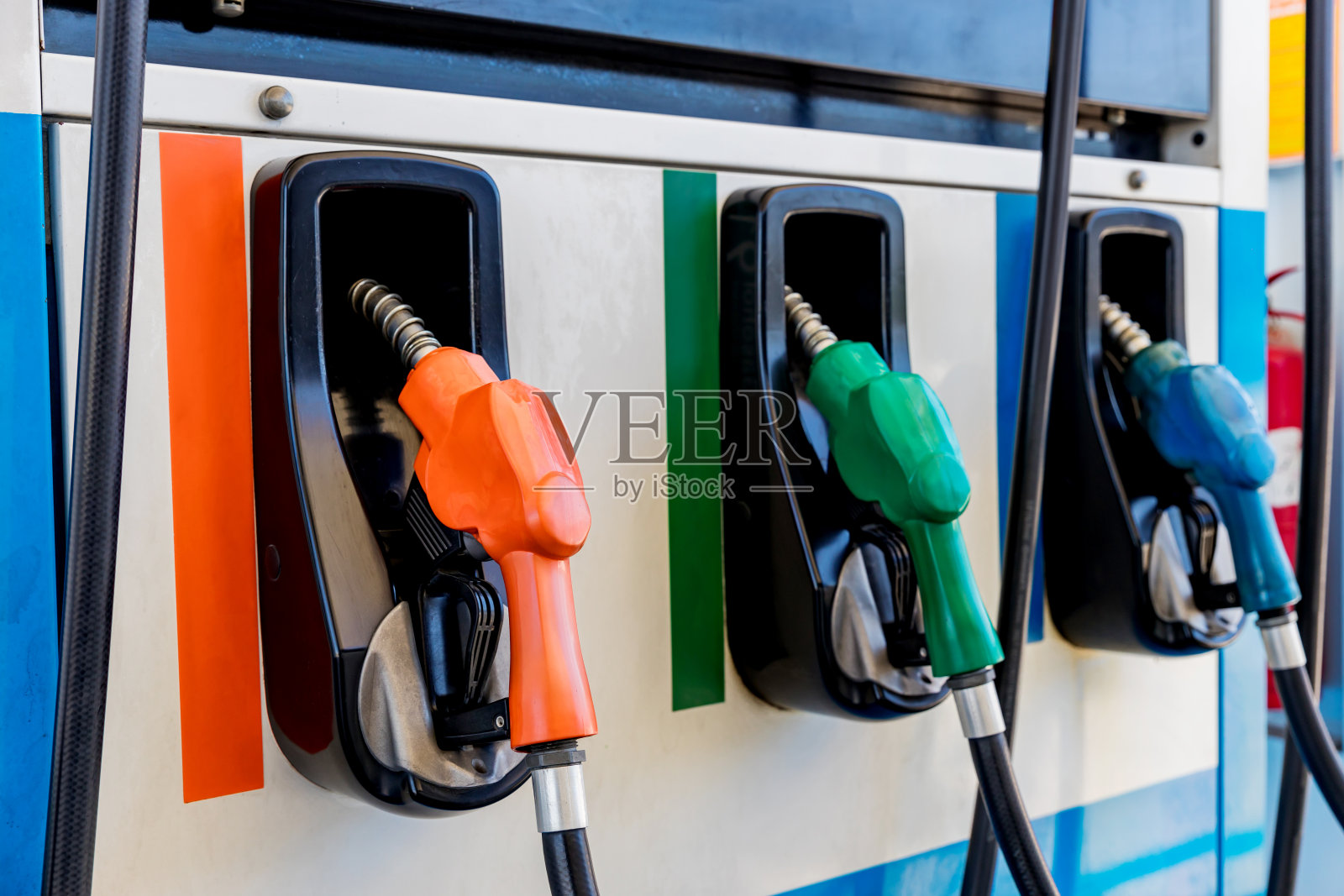 采购产品燃油泵,加油站,汽油。色彩斑斓的油泵加注喷嘴孤立在白色的背景上,加油站在温暖的夕阳下服务。亚洲首个燃油汽车加油设施照片摄影图片