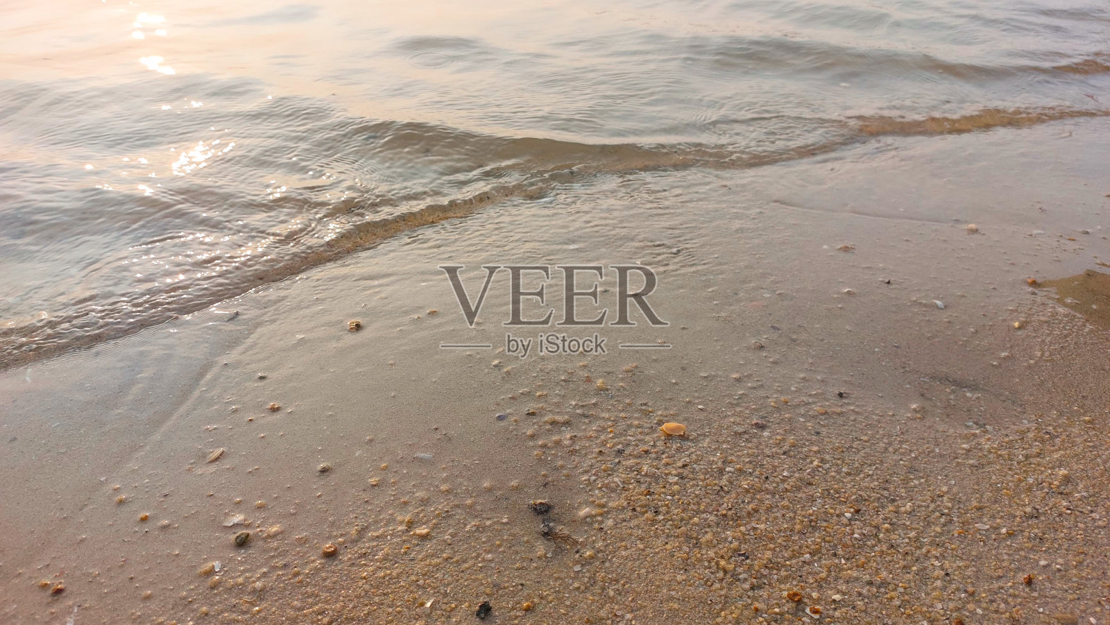 近景:柔和的海浪拍打着沙滩。自然抽象的背景和纹理照片摄影图片