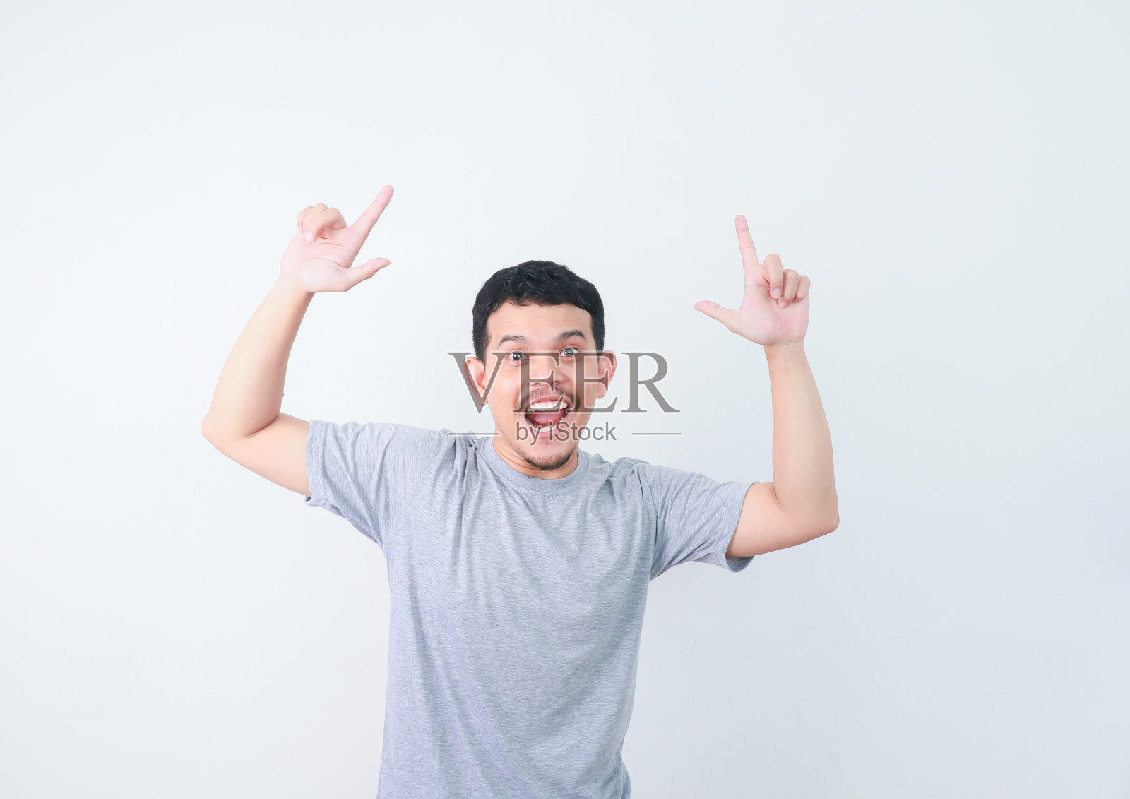 快乐的亚洲人正用手指着空的地方递东西。照片摄影图片