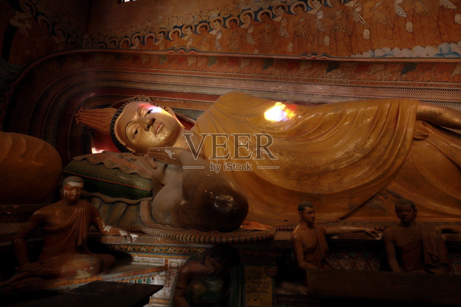 斯里兰卡佛寺内的大卧佛雕像,用绘画和壁画装饰。照片摄影图片