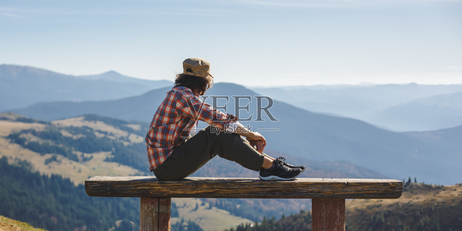 一名男子在长凳上休息,欣赏乌克兰的山景照片摄影图片