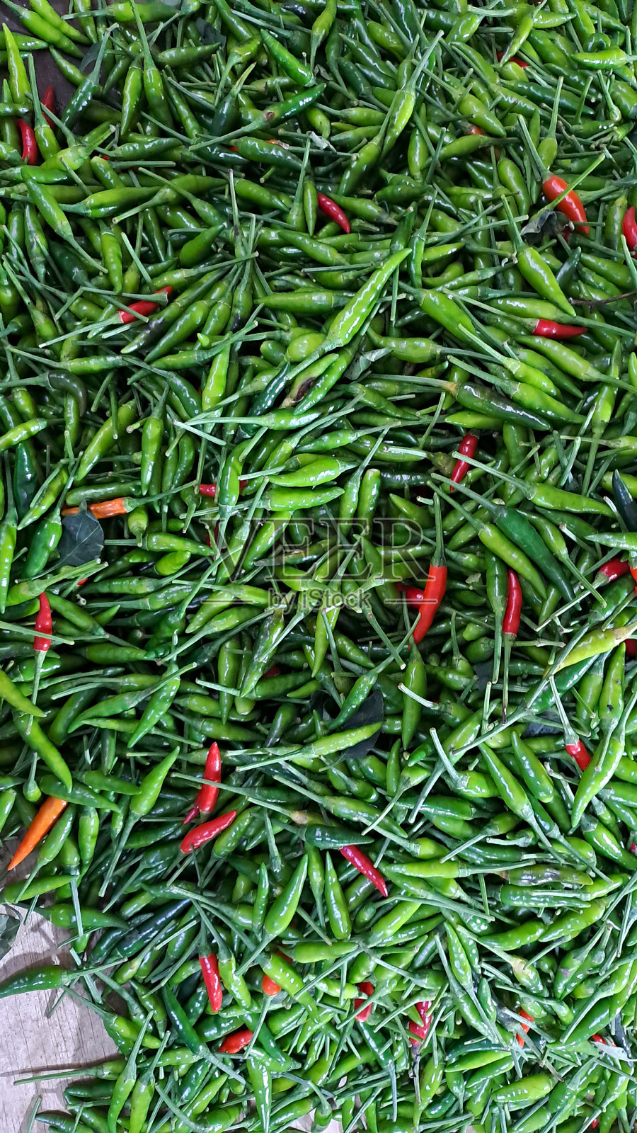 市场上一堆绿辣椒的漂亮特写,上面有一些红辣椒照片摄影图片