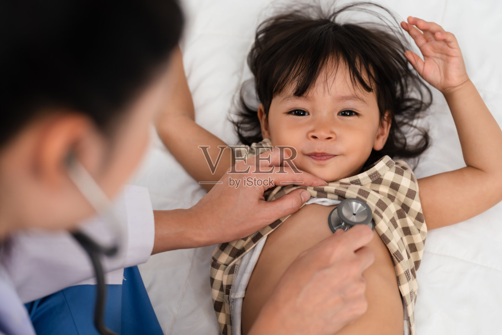 医生用听诊器听幼儿的胸部。婴儿健康理念照片摄影图片