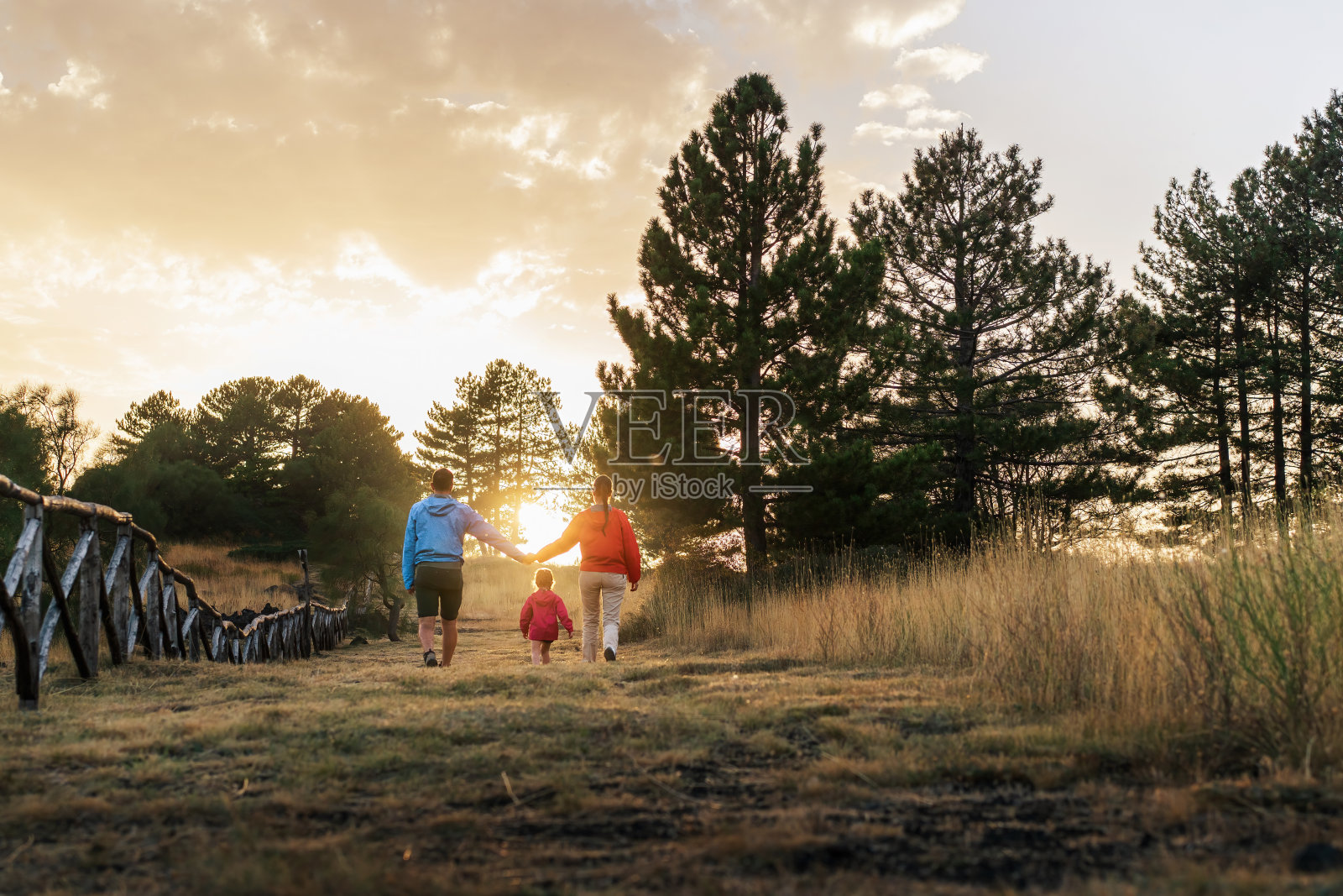 一个男人和一个女人带着他们的孩子在野外散步,这是一个坦率的家庭时刻照片摄影图片