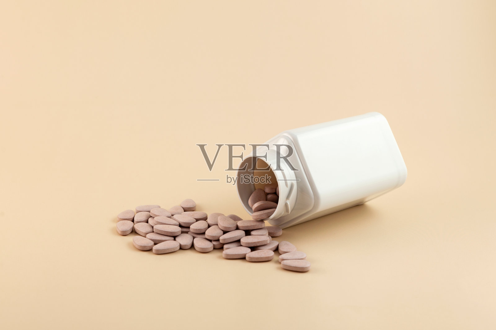 从塑料瓶里倒出药片或维生素补充剂。健康的补品。多种维生素,维生素B, C, D,片剂,益生菌,铁。排毒的概念照片摄影图片