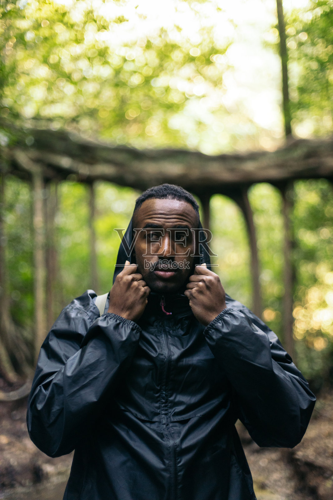 一个人在森林里戴上雨衣的兜帽照片摄影图片