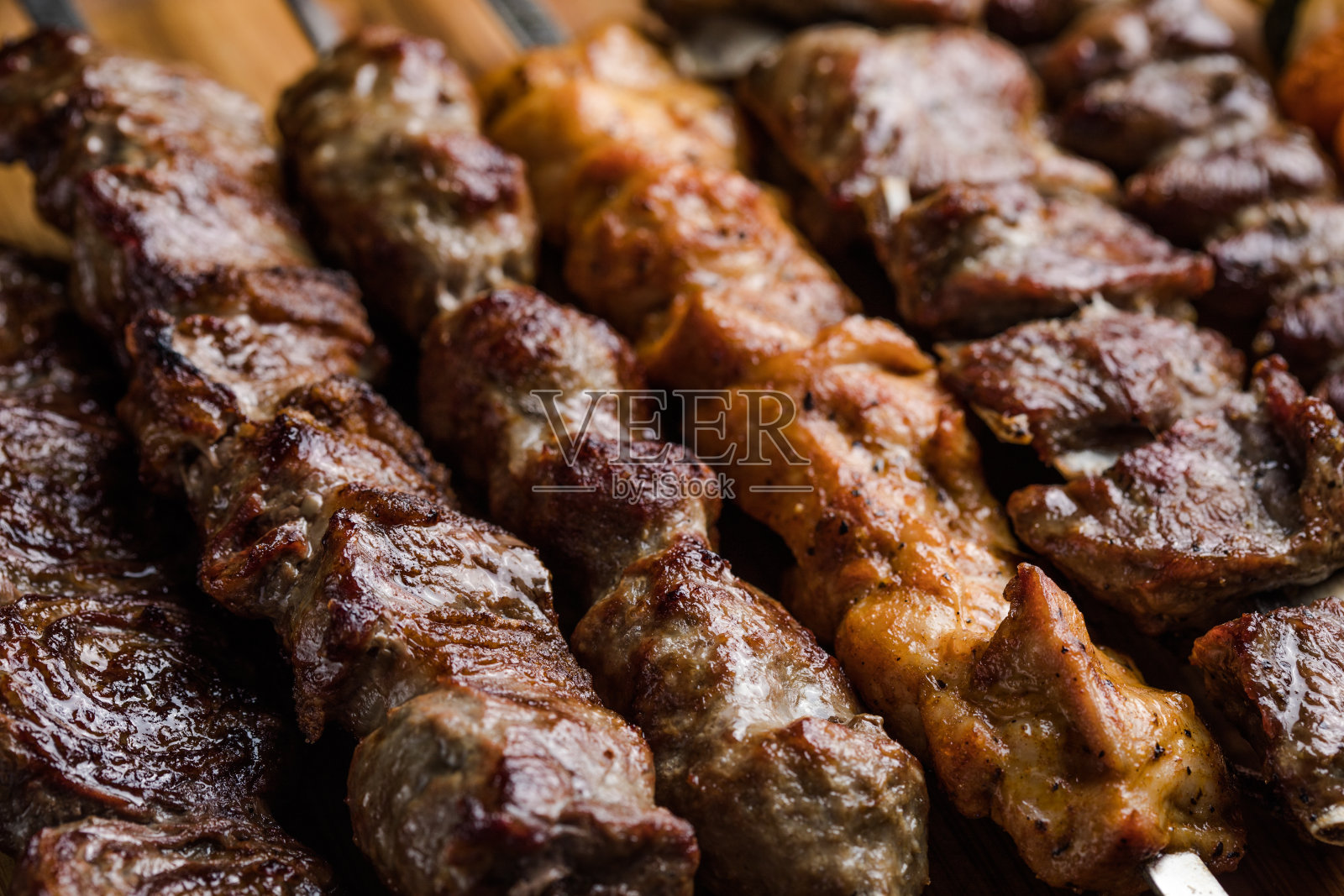 在木炭烤架上准备的腌肉串。羊肉串最初是用羊肉做的。在烧烤架上烤牛肉串。照片摄影图片
