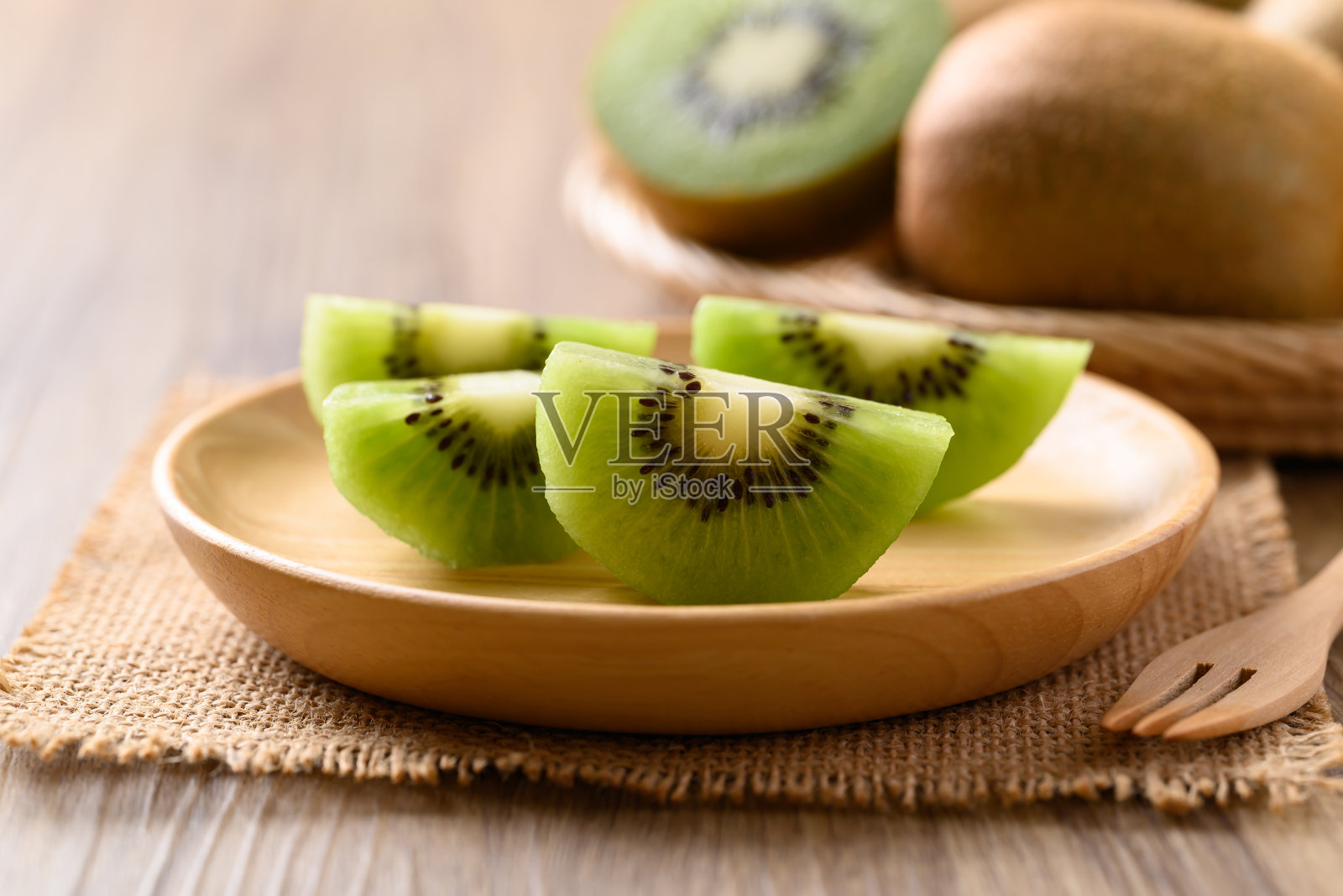 绿色猕猴桃切片装在木盘上即可食用,健康水果照片摄影图片