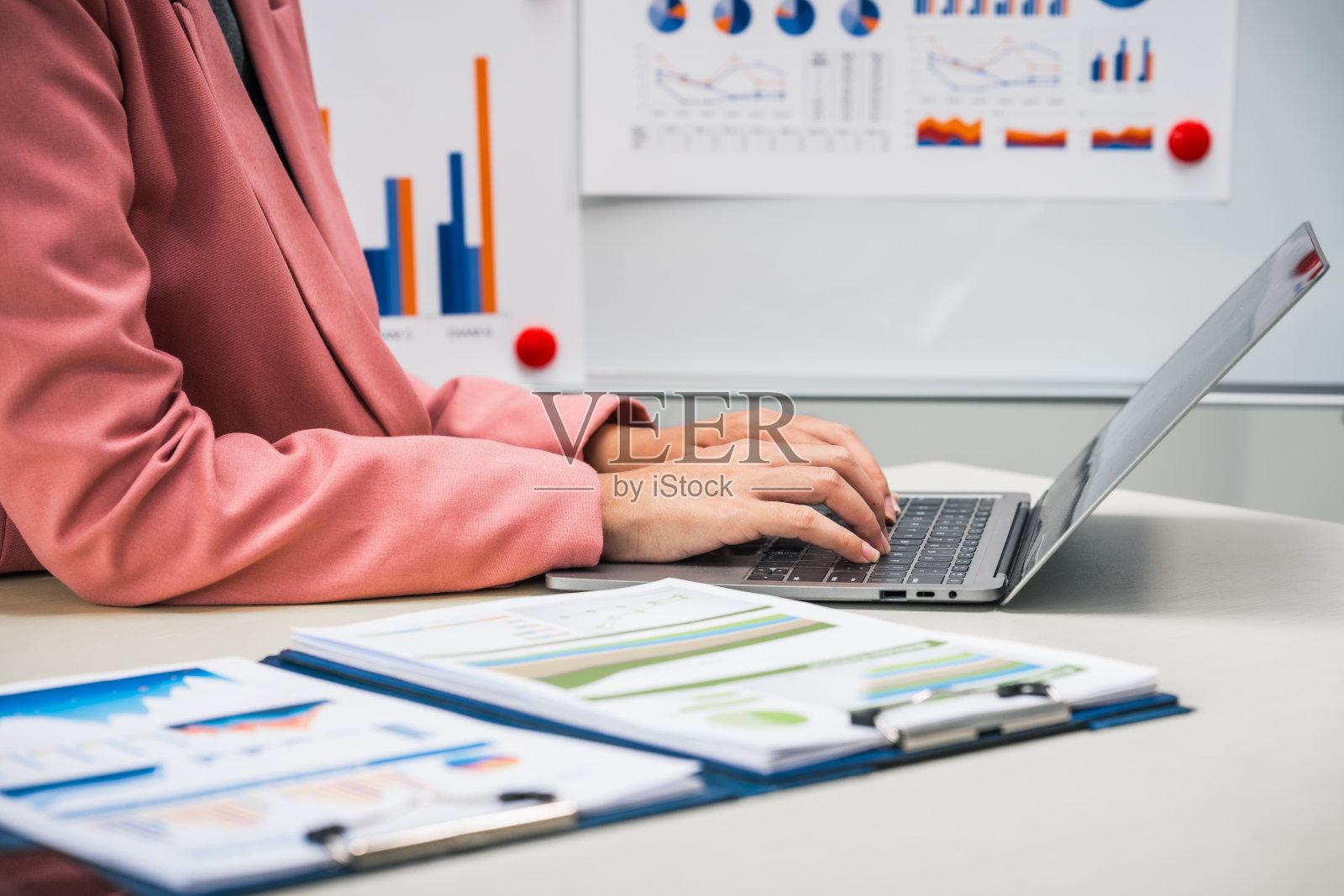 女商人在她的办公桌前勤奋地工作,审阅财务文件,分析投资数据。她确保财务计算和审计过程的准确性和效率。照片摄影图片