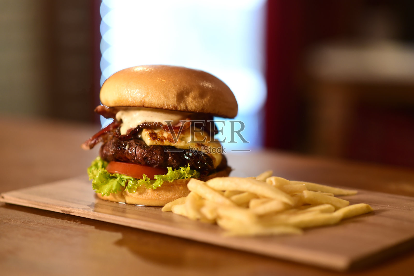 牛肉汉堡,三明治,面包,沙拉,洋葱和奶酪快餐,孤立在木桌上照片摄影图片