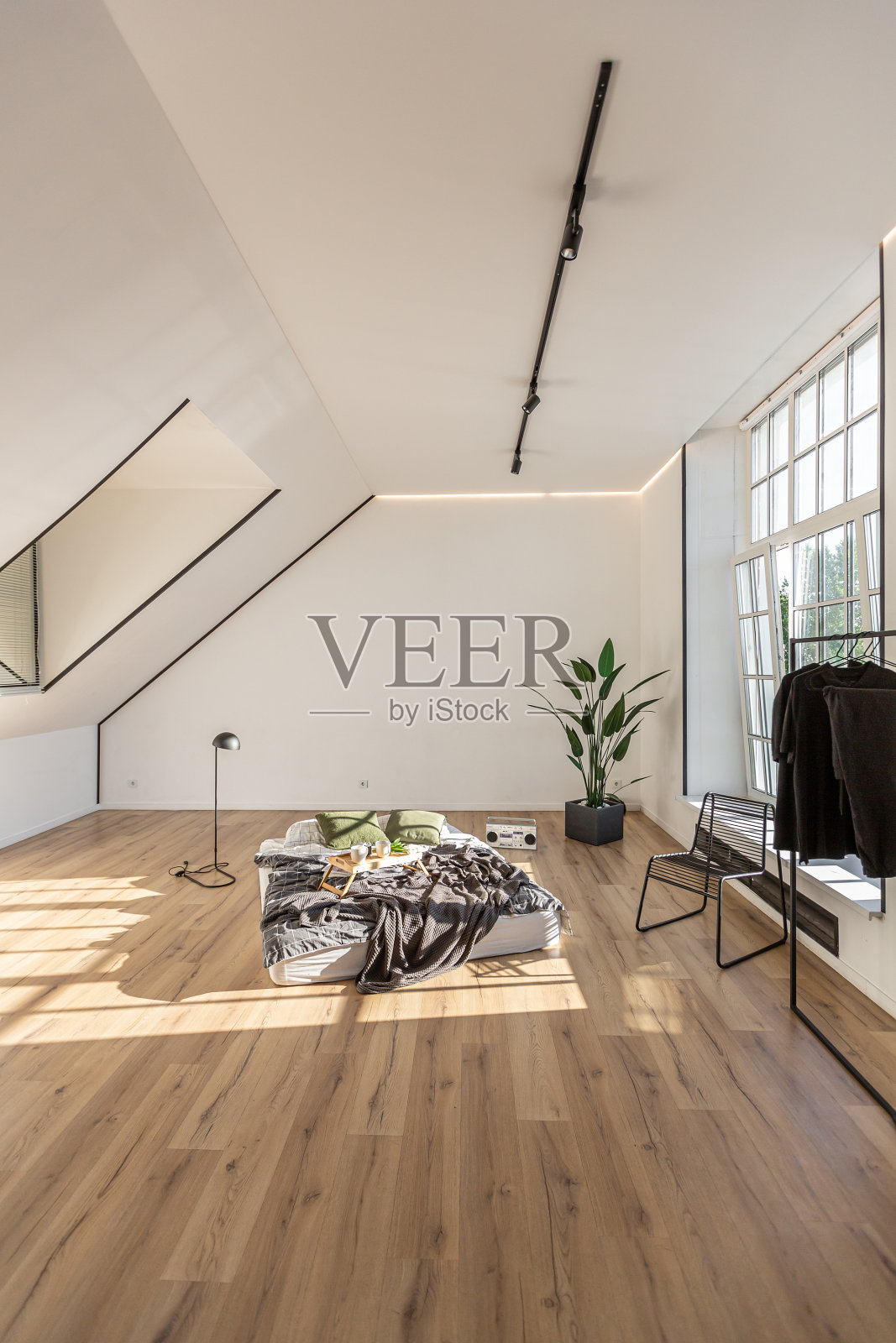 极简风格的室内白色简单卧室,天花板上有窗户,没有人的阳光照片摄影图片