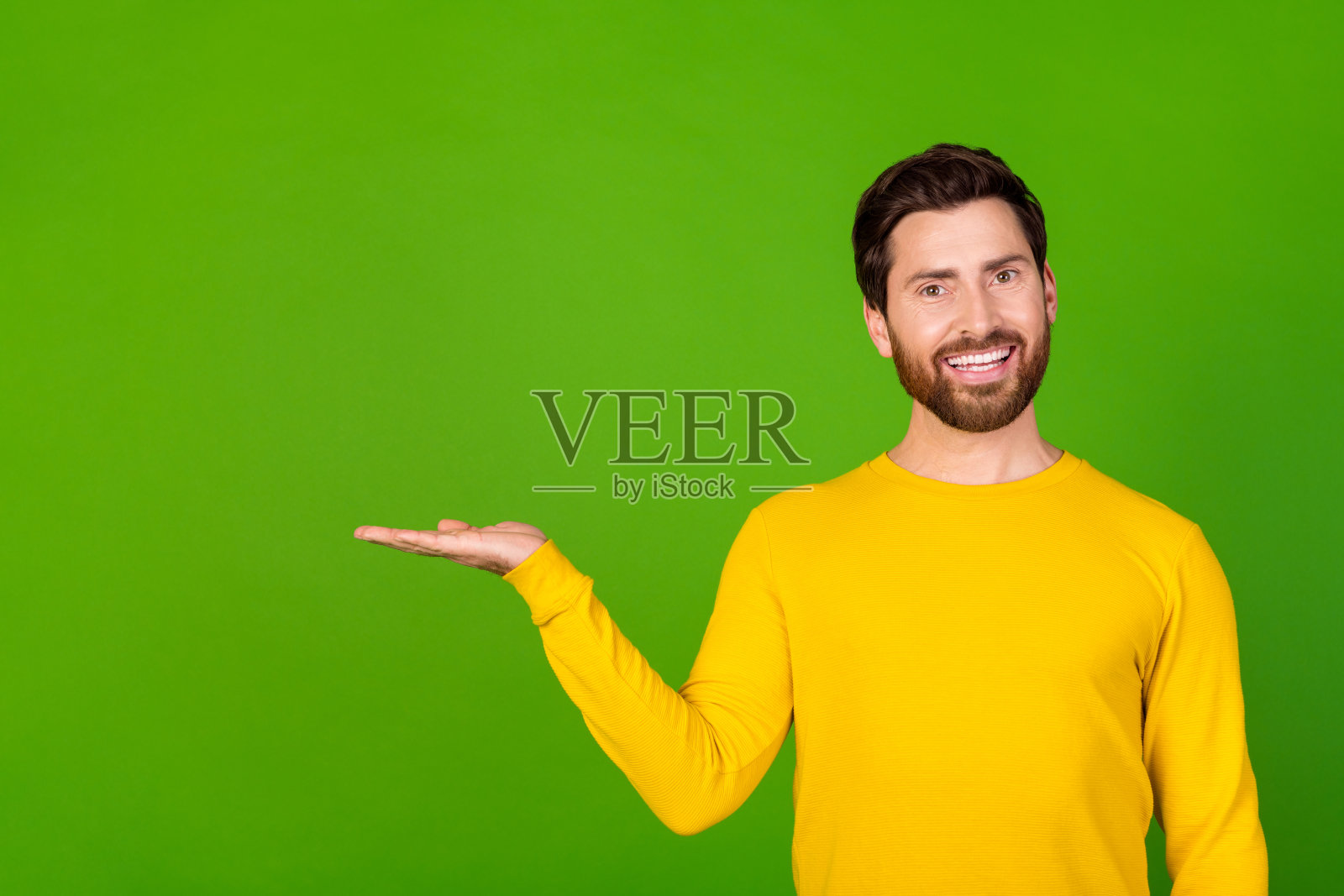 照片肖像的迷人的年轻人持有空白空间穿着时尚的黄色衣服孤立的绿色背景照片摄影图片