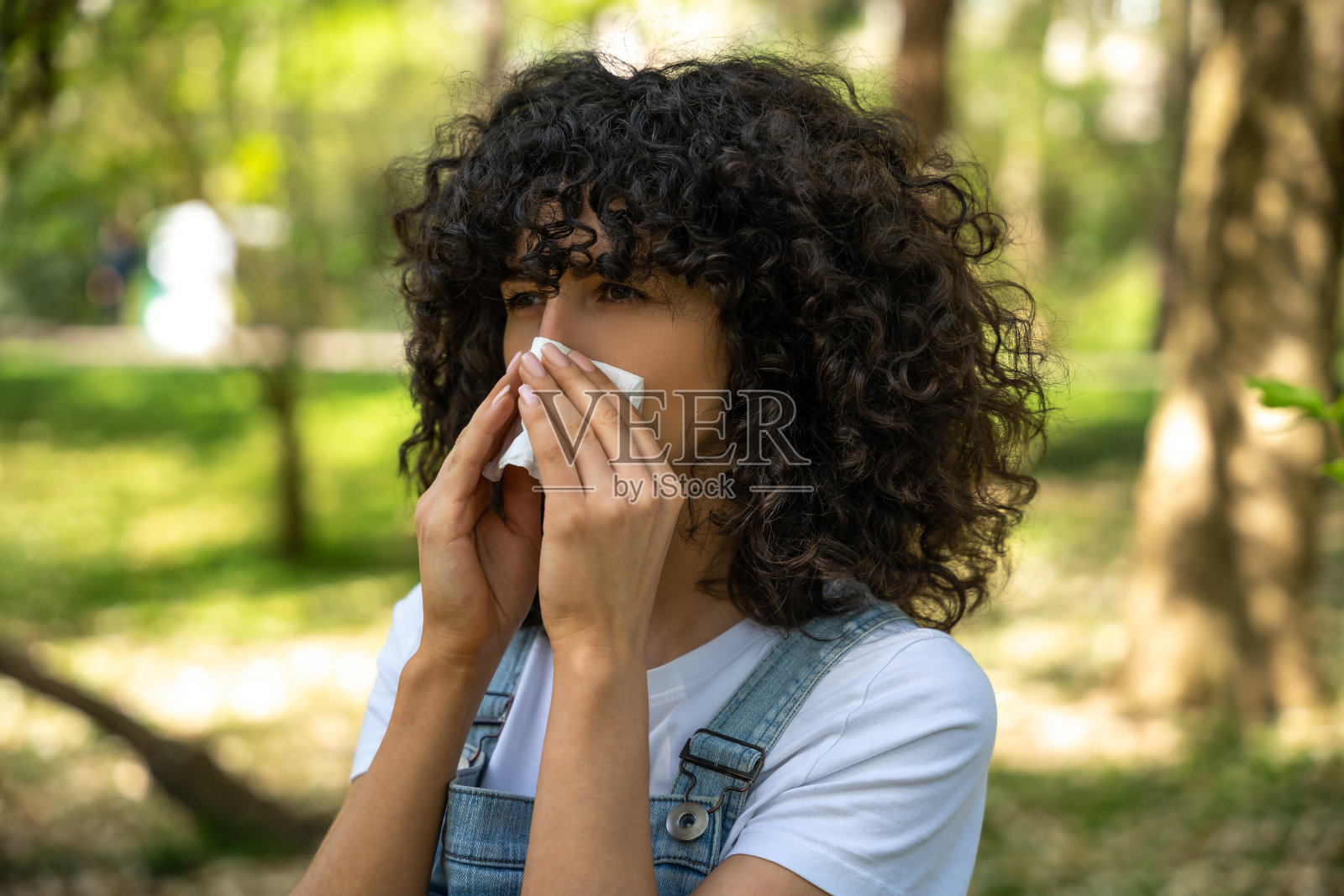 患有季节性过敏的卷发年轻女子照片摄影图片