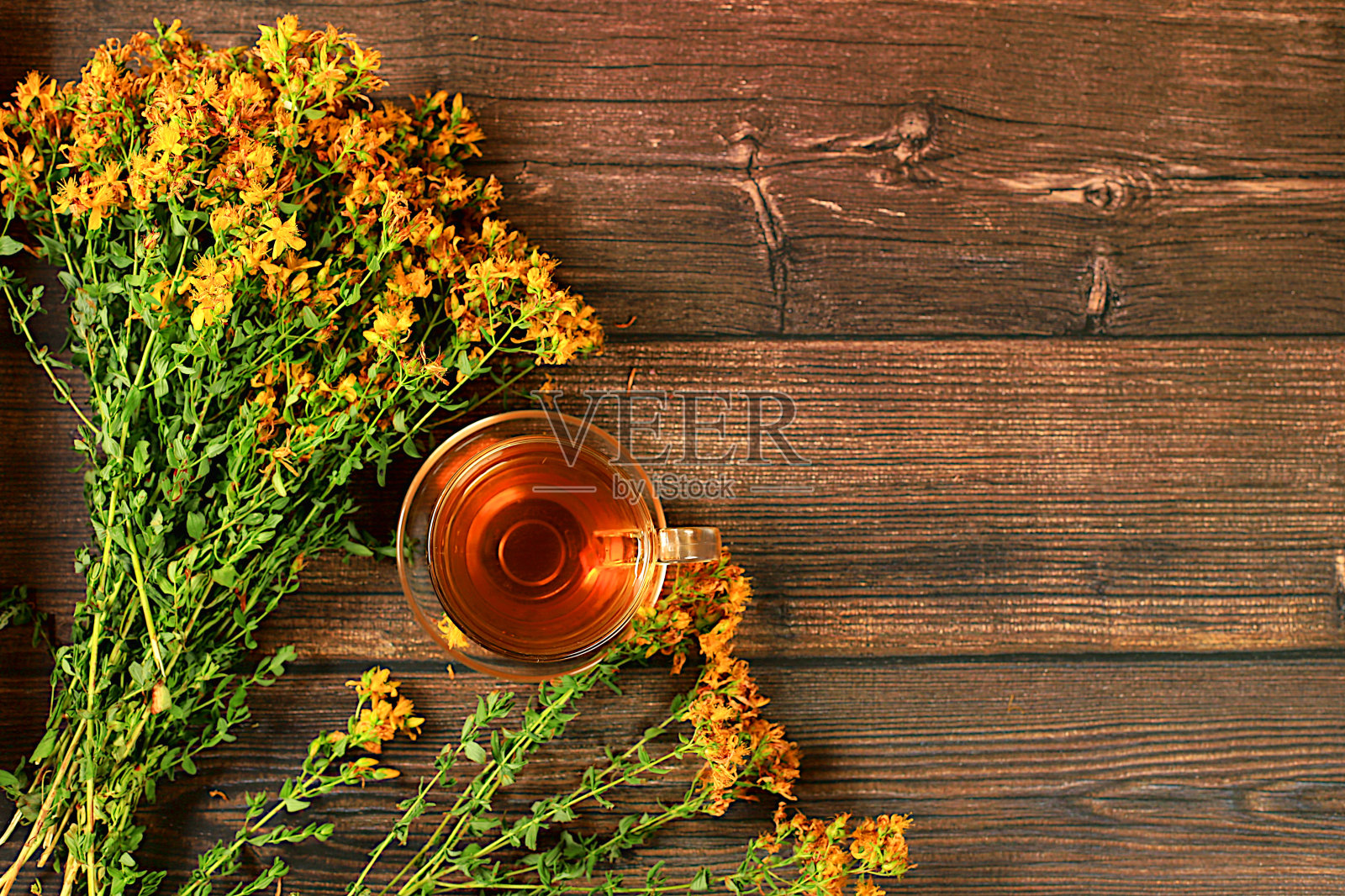 药用凉茶或金丝桃在玻璃杯中灌注鲜花,替代传统医学的概念,绿色药房广告,根据民间配方收集健康草药进行治疗,照片摄影图片