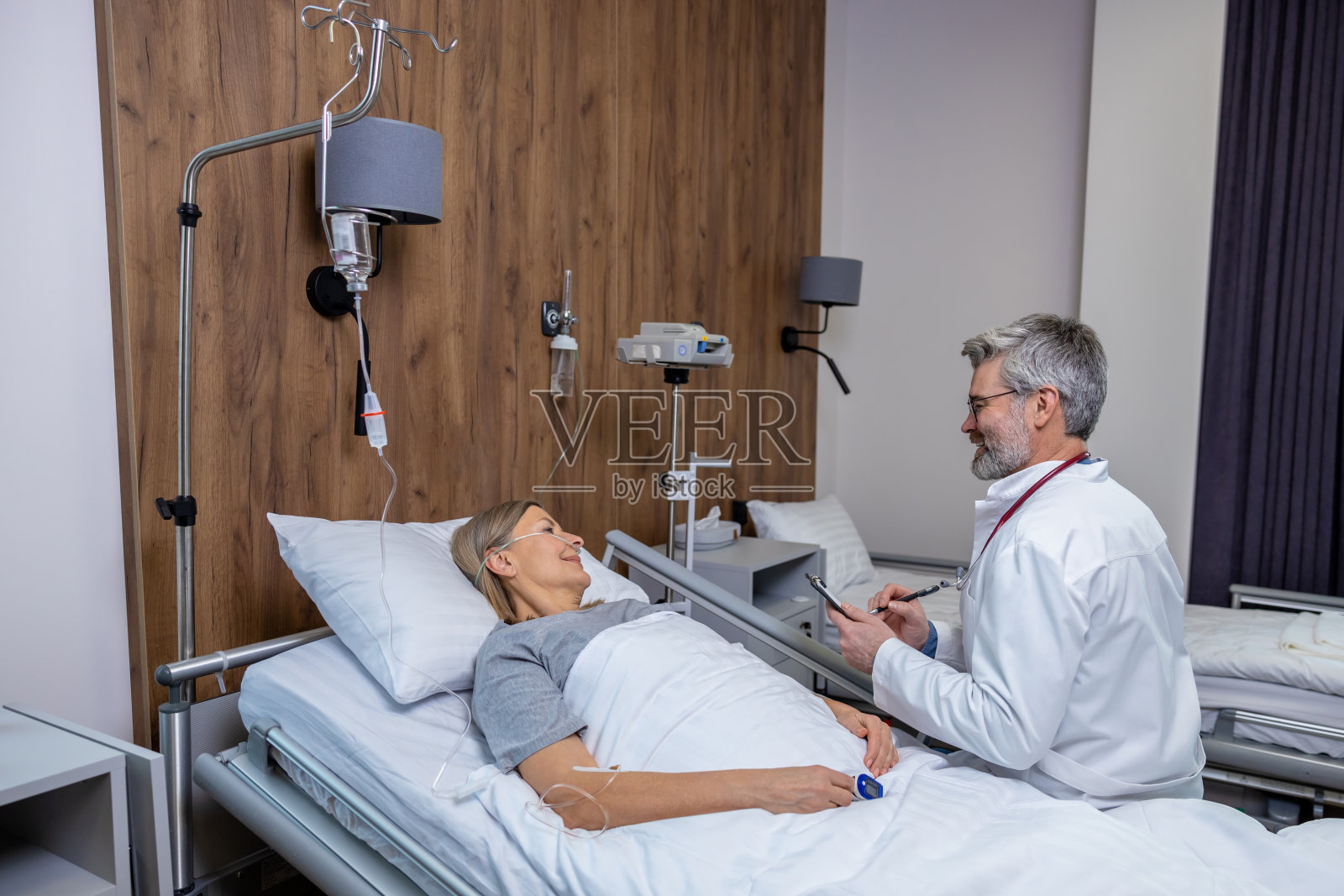 医生在诊所和病人谈话,看起来很关心照片摄影图片