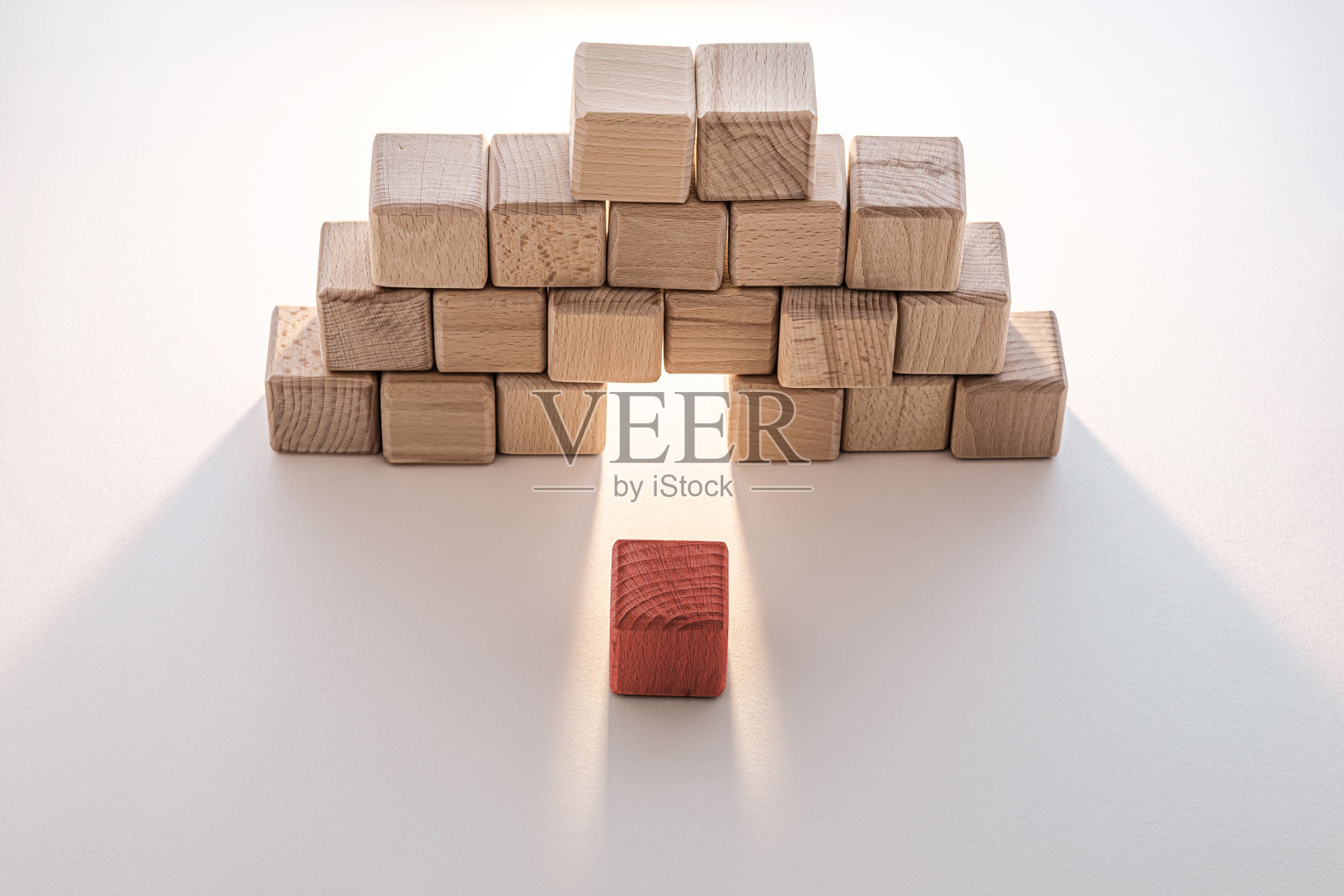 一个单独的红色块从木块墙中浮现出来照片摄影图片