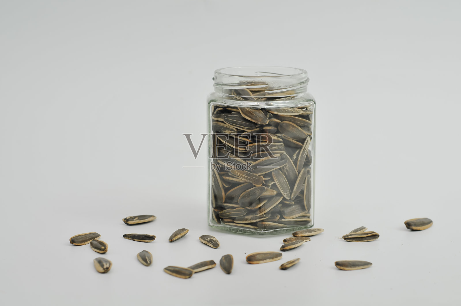 白色背景的罐子里的葵花籽照片摄影图片