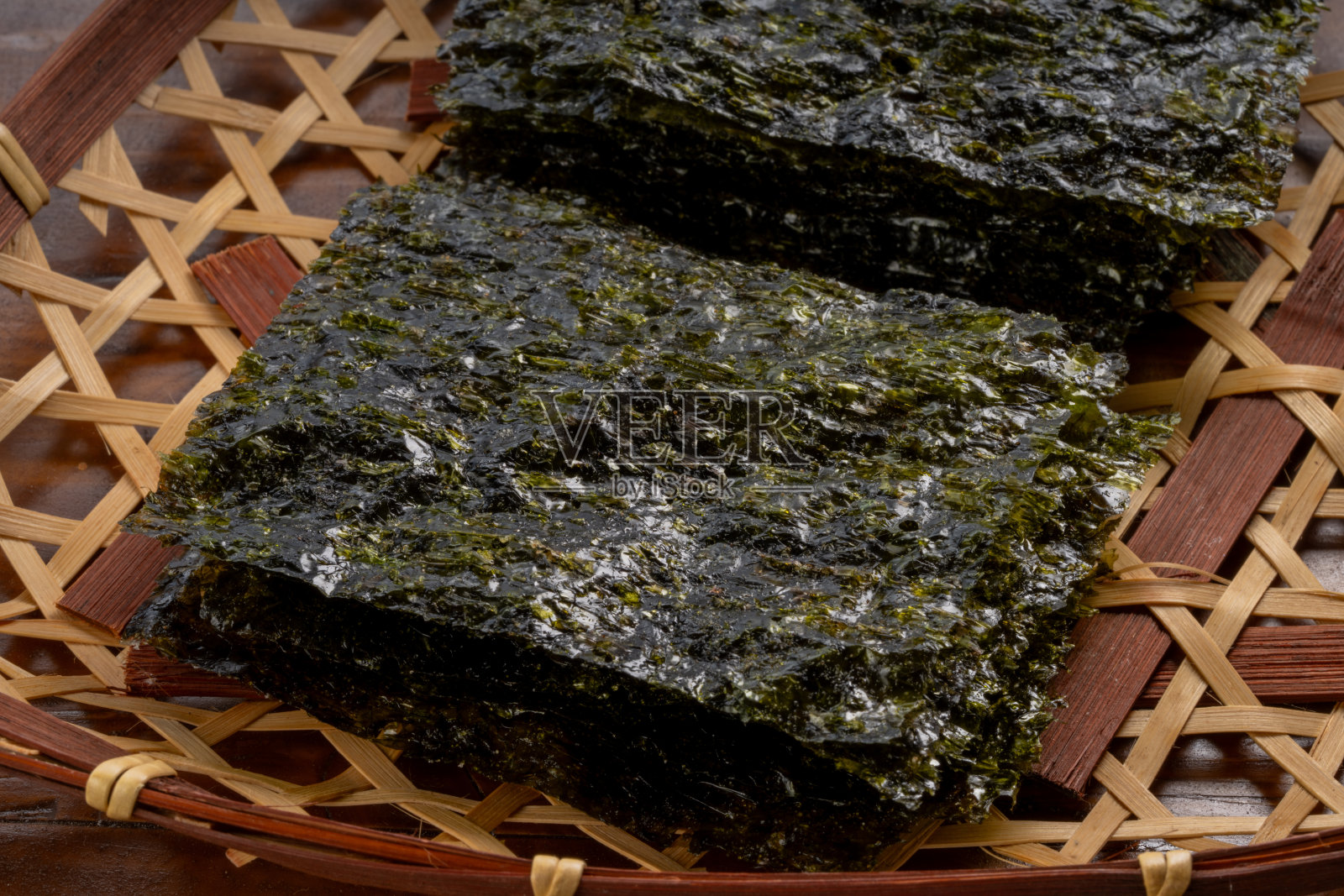 韩国干海带片,海带片或紫菜片,在木制背景的木制篮子。照片摄影图片