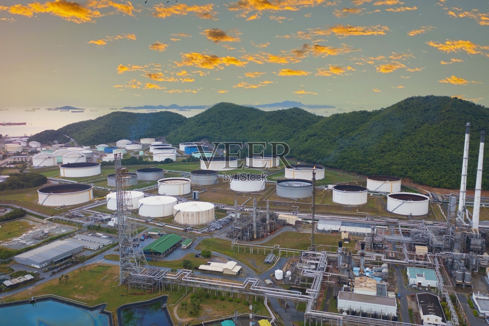 夕阳与炼油厂形成以化工厂-石化厂为蓝天背景的工业区照片摄影图片