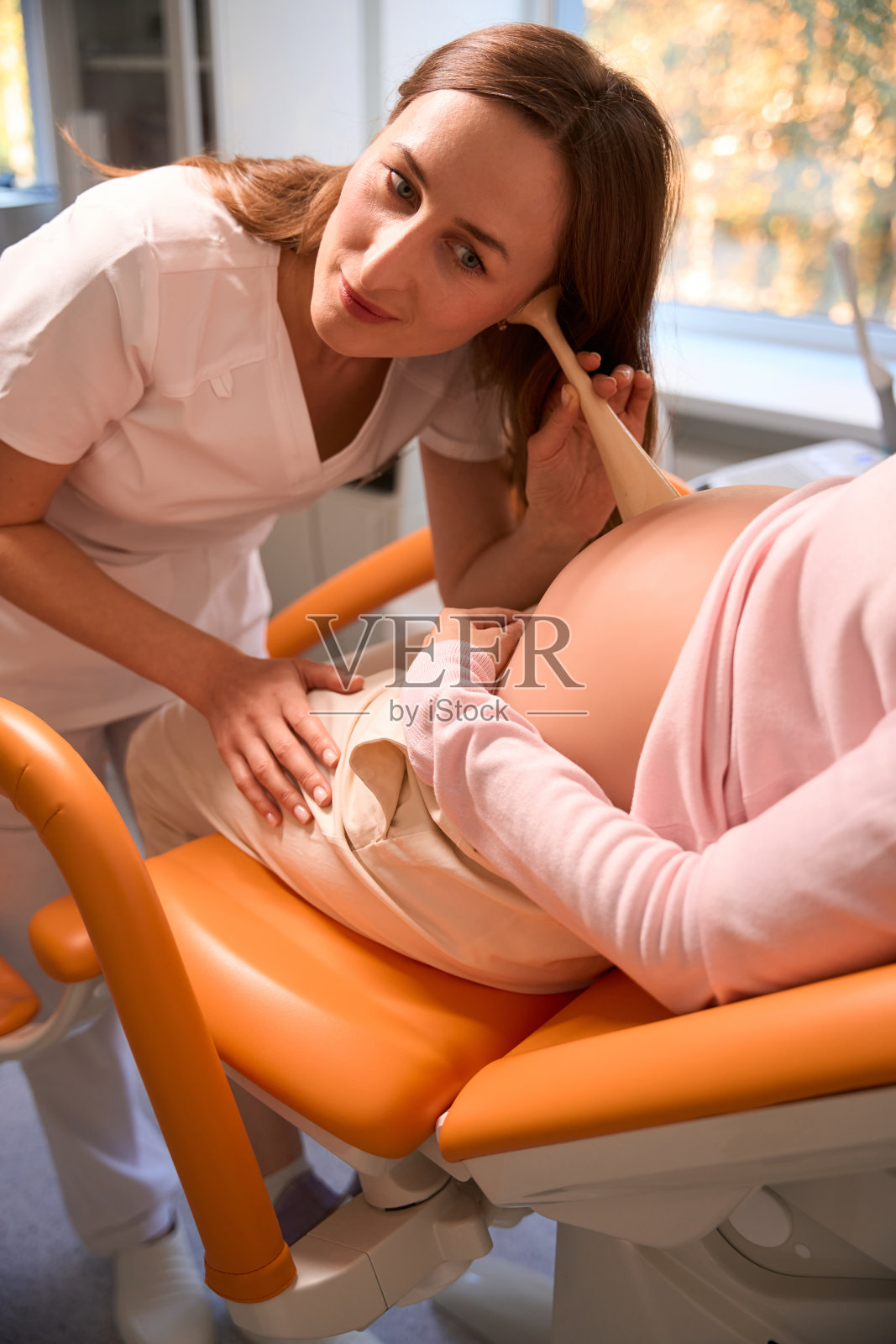 友好的医生检查孕妇听婴儿的心跳照片摄影图片