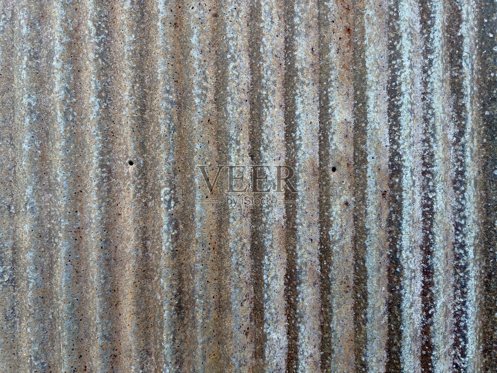 锈迹斑斑的金属棚墙呈现出风化的纹理和丰富的铜绿,体现了工业衰败和崎岖之美,其锈蚀的表面讲述了一个关于时间和韧性的故事。照片摄影图片