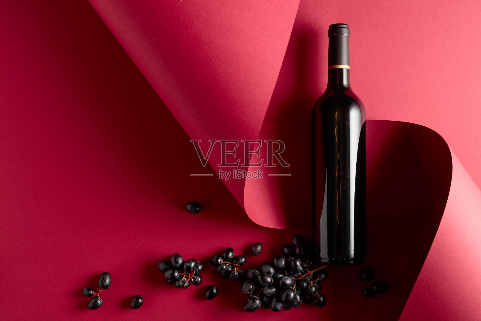 一瓶红酒和蓝葡萄。照片摄影图片