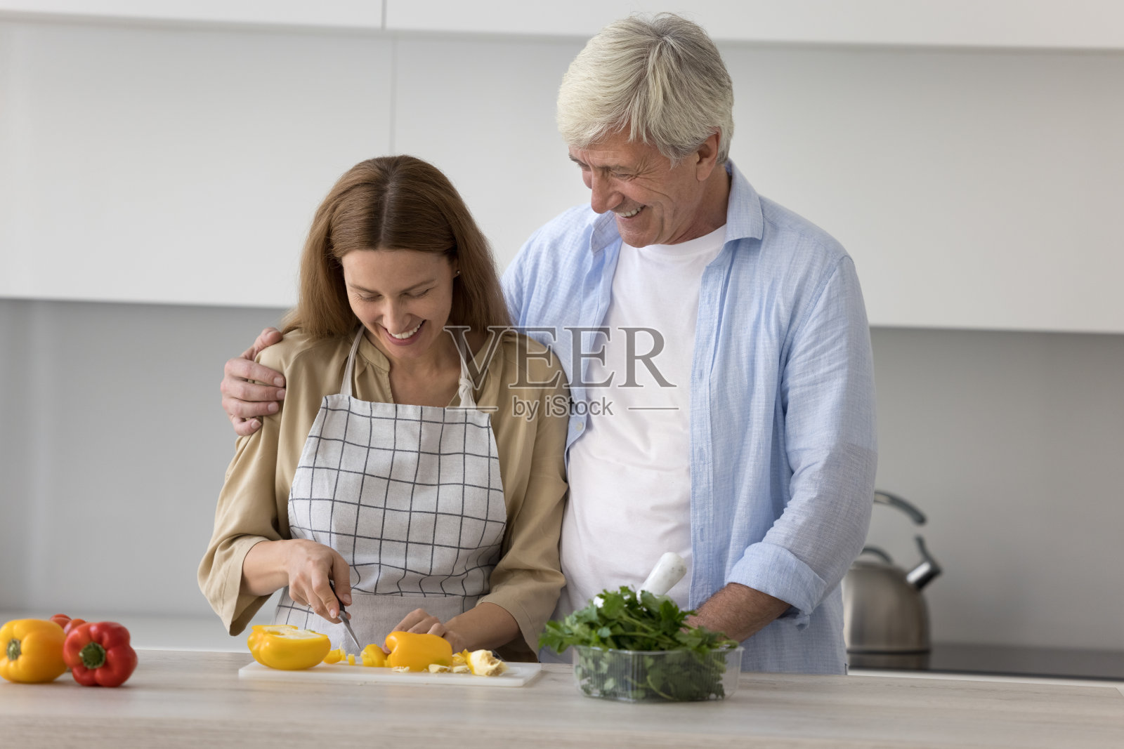 千禧一代的女性帮助年迈的父亲做晚饭照片摄影图片