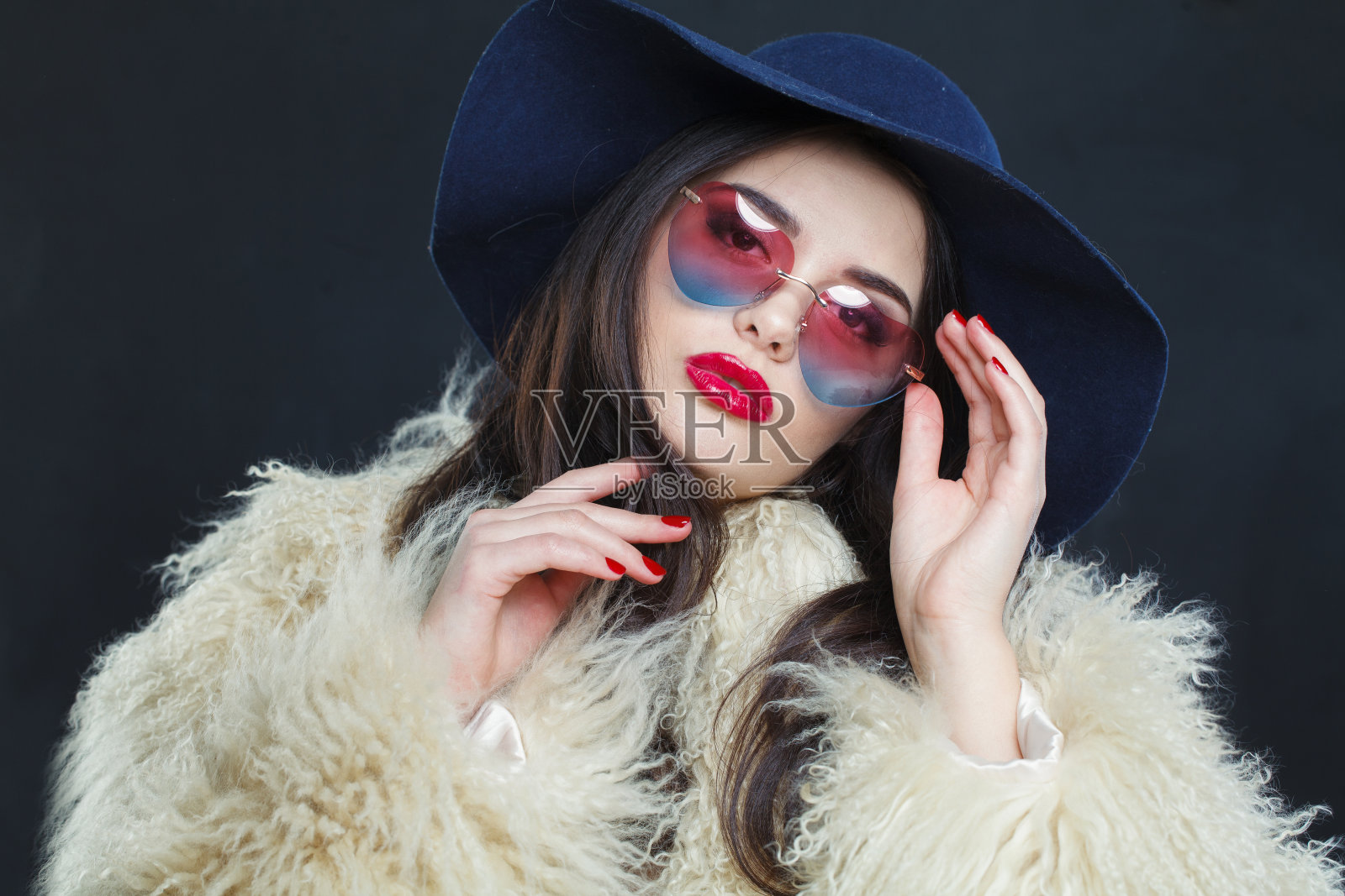 优雅的时尚模特女人,深色波浪发型,红唇,化妆,戴着时尚的帽子,美丽的工作室肖像照片摄影图片