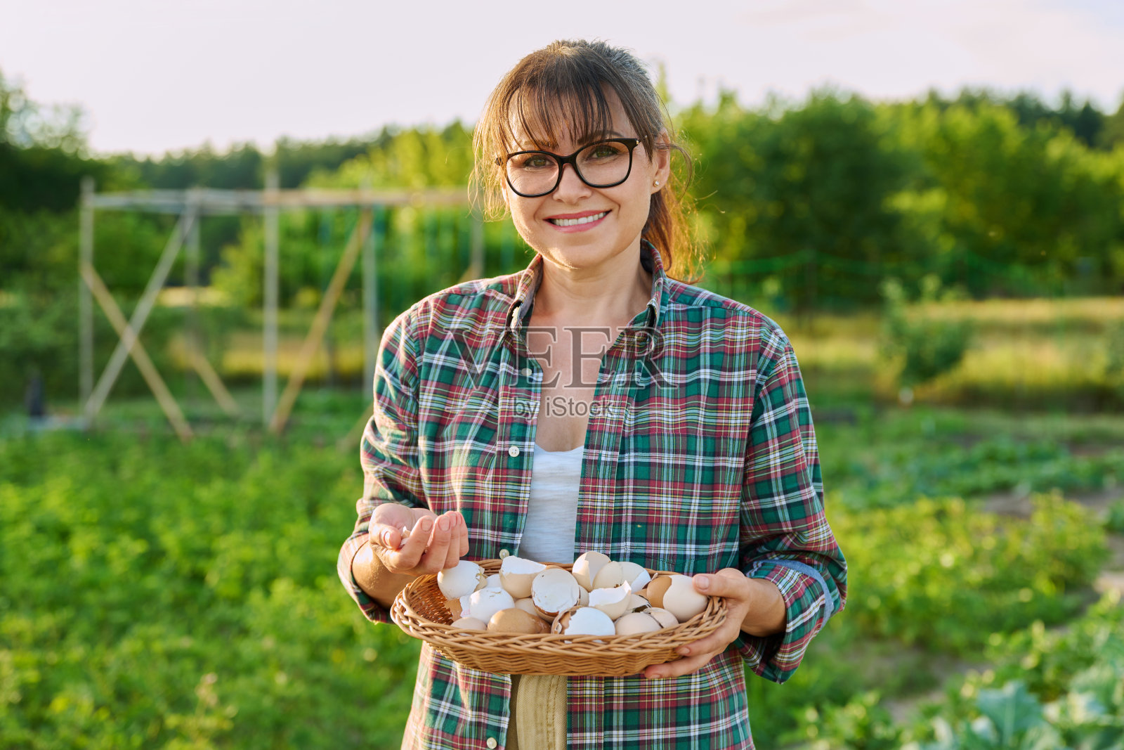 柳条碗里装着蛋壳的女人,户外花园背景照片摄影图片