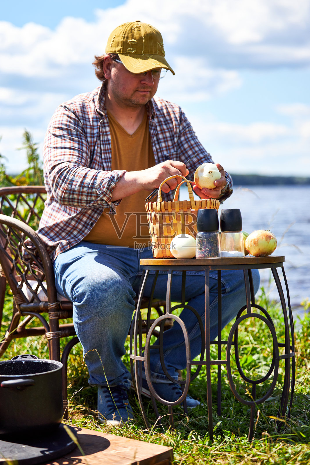 一个人去野餐,站在一个打开的汽车后备箱旁边,里面有一堆东西照片摄影图片