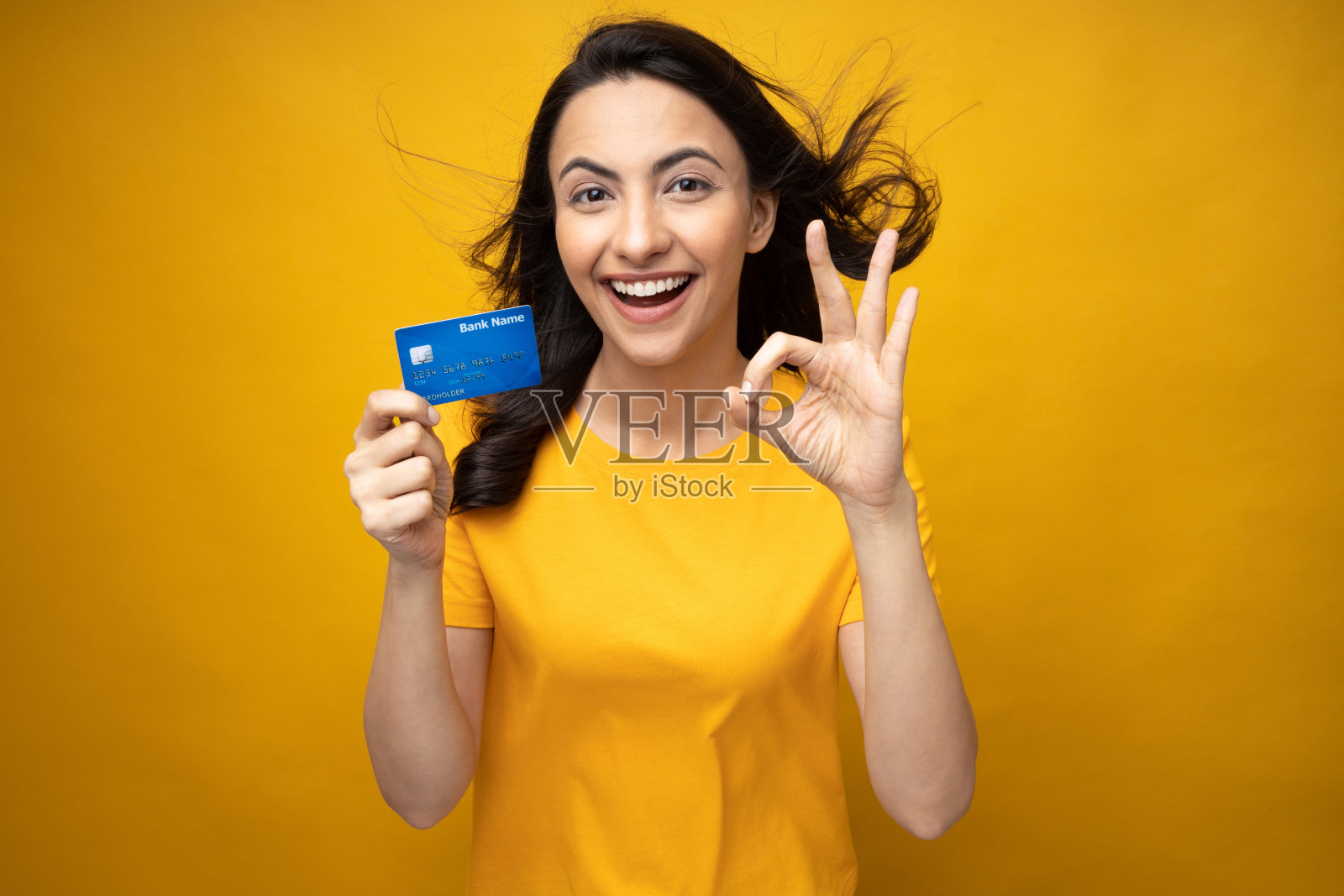 年轻女子显示信用卡孤立的黄色背景股票照片照片摄影图片