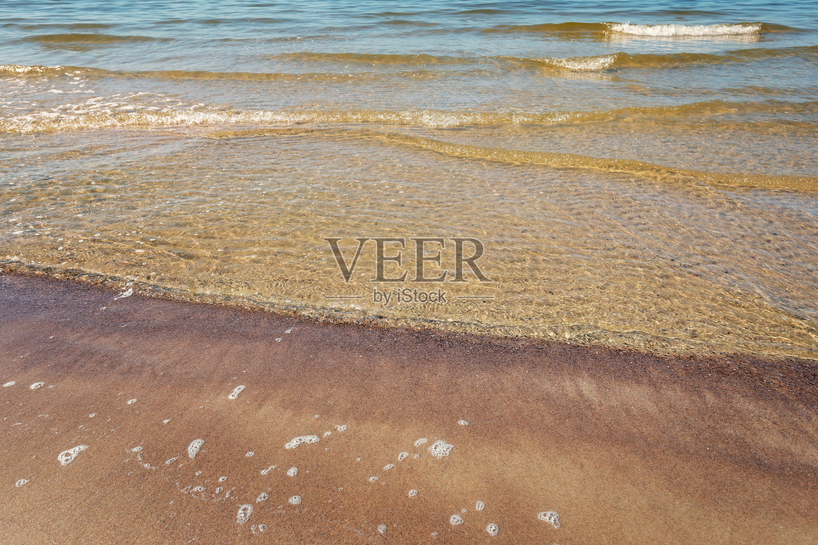 靠近蓝色的波罗的海海浪与泡沫在沙滩上照片摄影图片