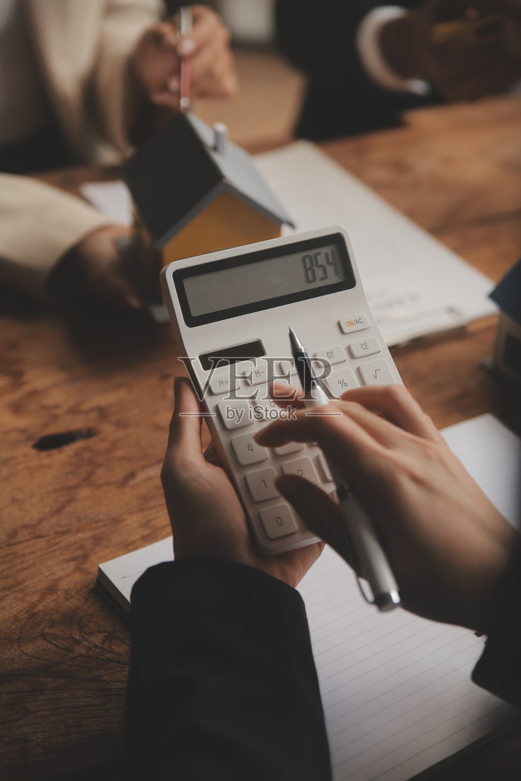 房地产经纪人和销售经理团队分析租赁合同、买卖协议、按揭贷款报价和房屋保险的定价。照片摄影图片