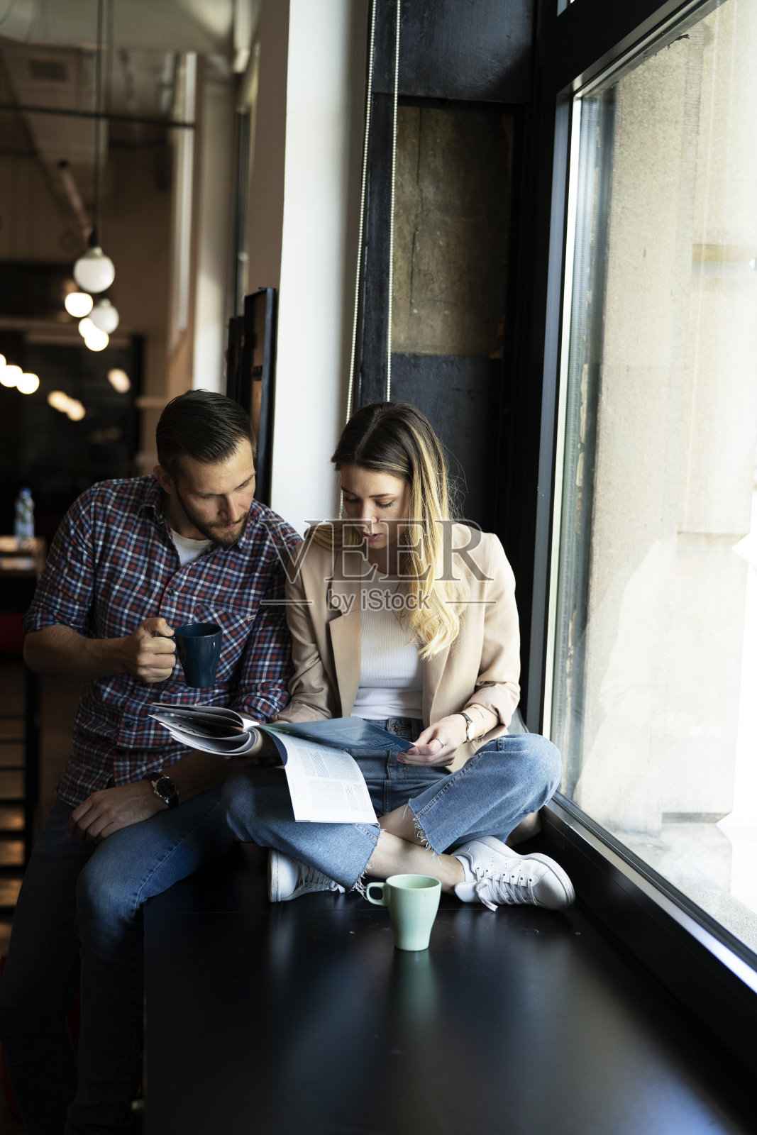 一个商人和一个女商人在办公室喝咖啡。照片摄影图片