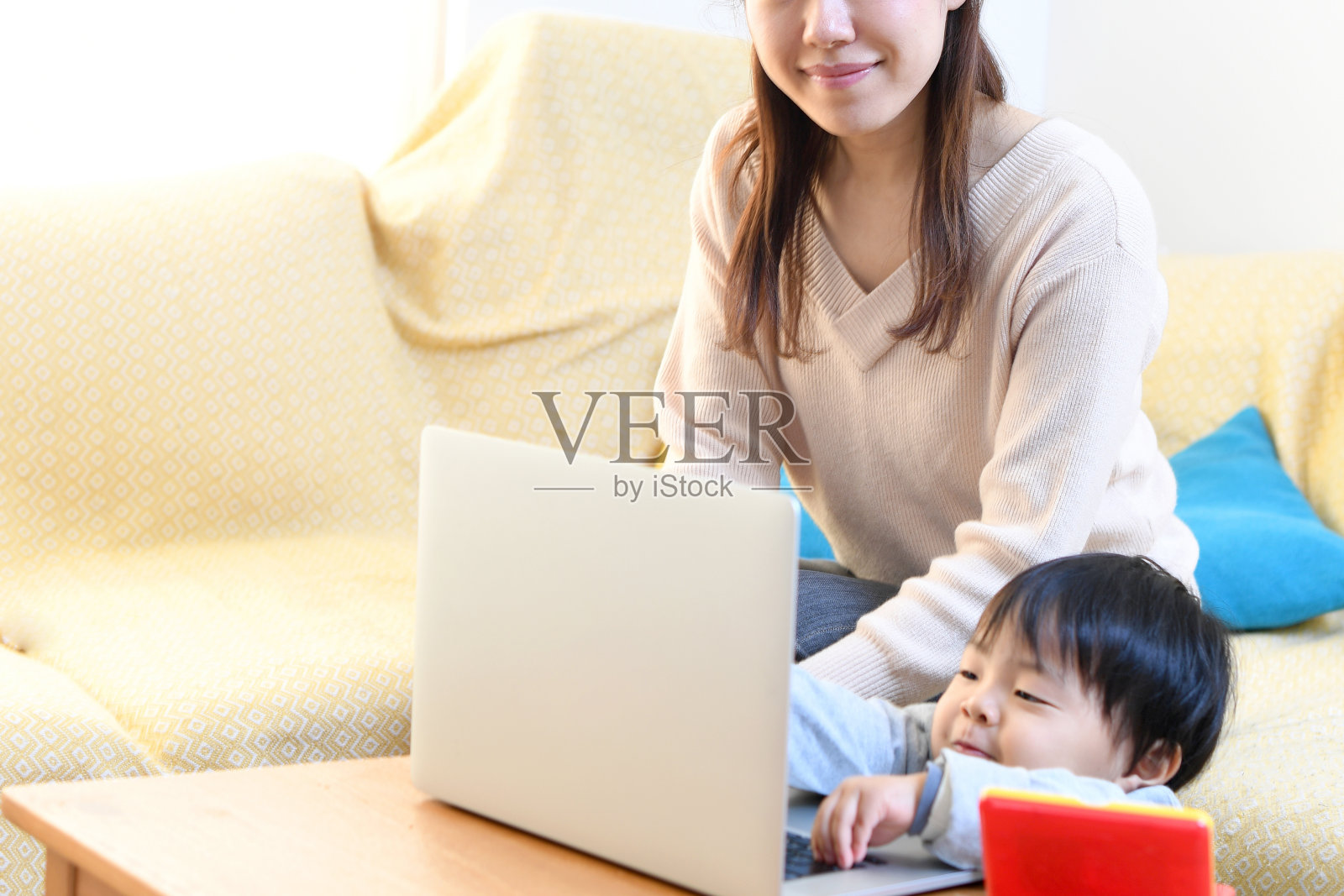 一位年轻的亚洲妇女的母亲和她的小男孩玩过家家照片摄影图片