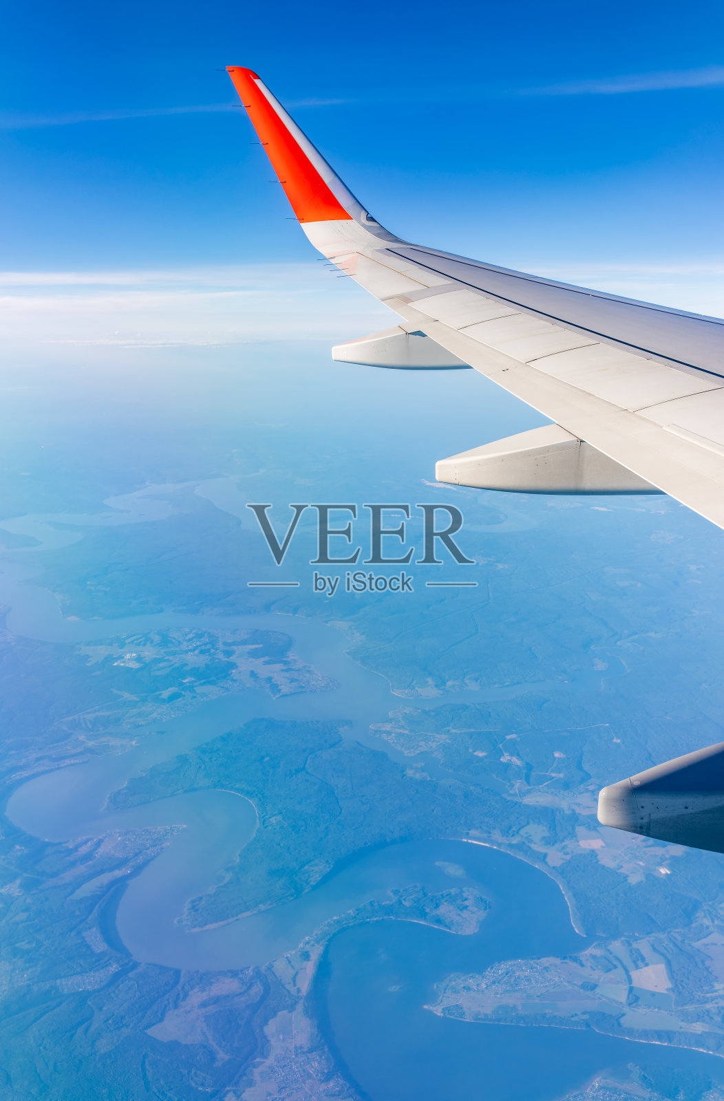 从飞机窗口俯瞰绿色地面。从飞机窗口看到日出时美丽的云照片摄影图片