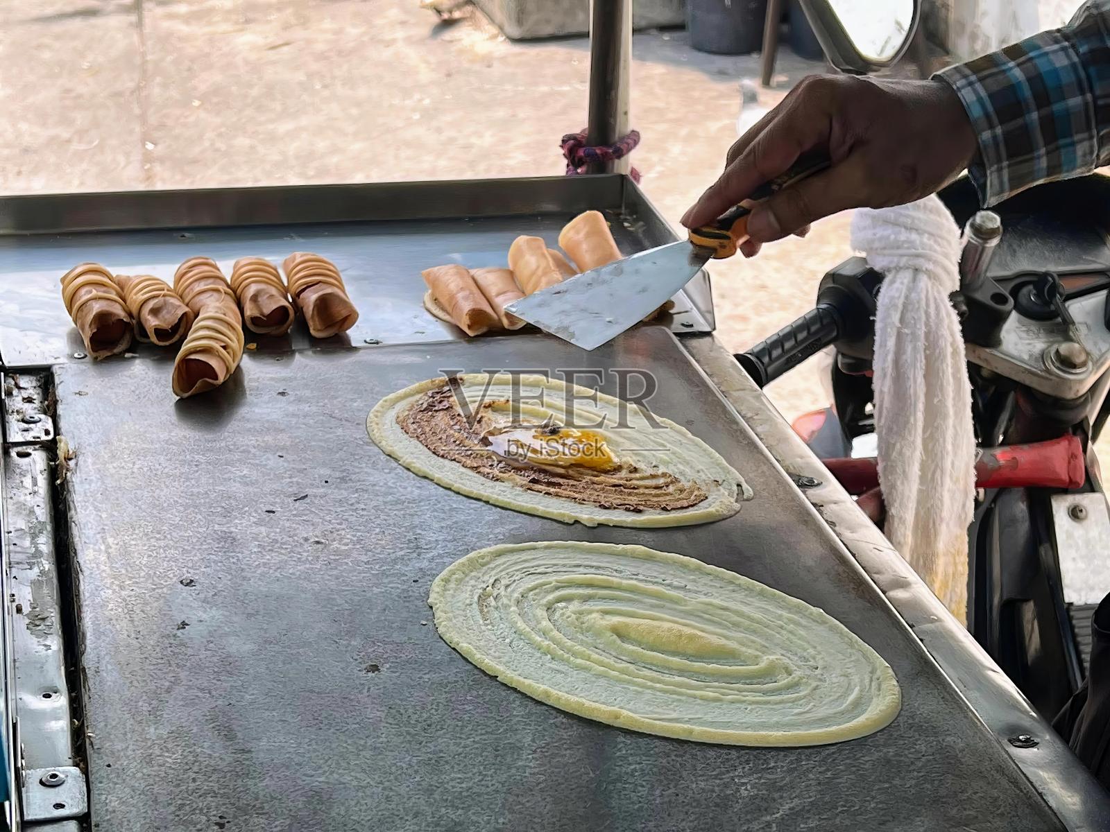 一个人在烤架上用刀做食物的照片。照片摄影图片