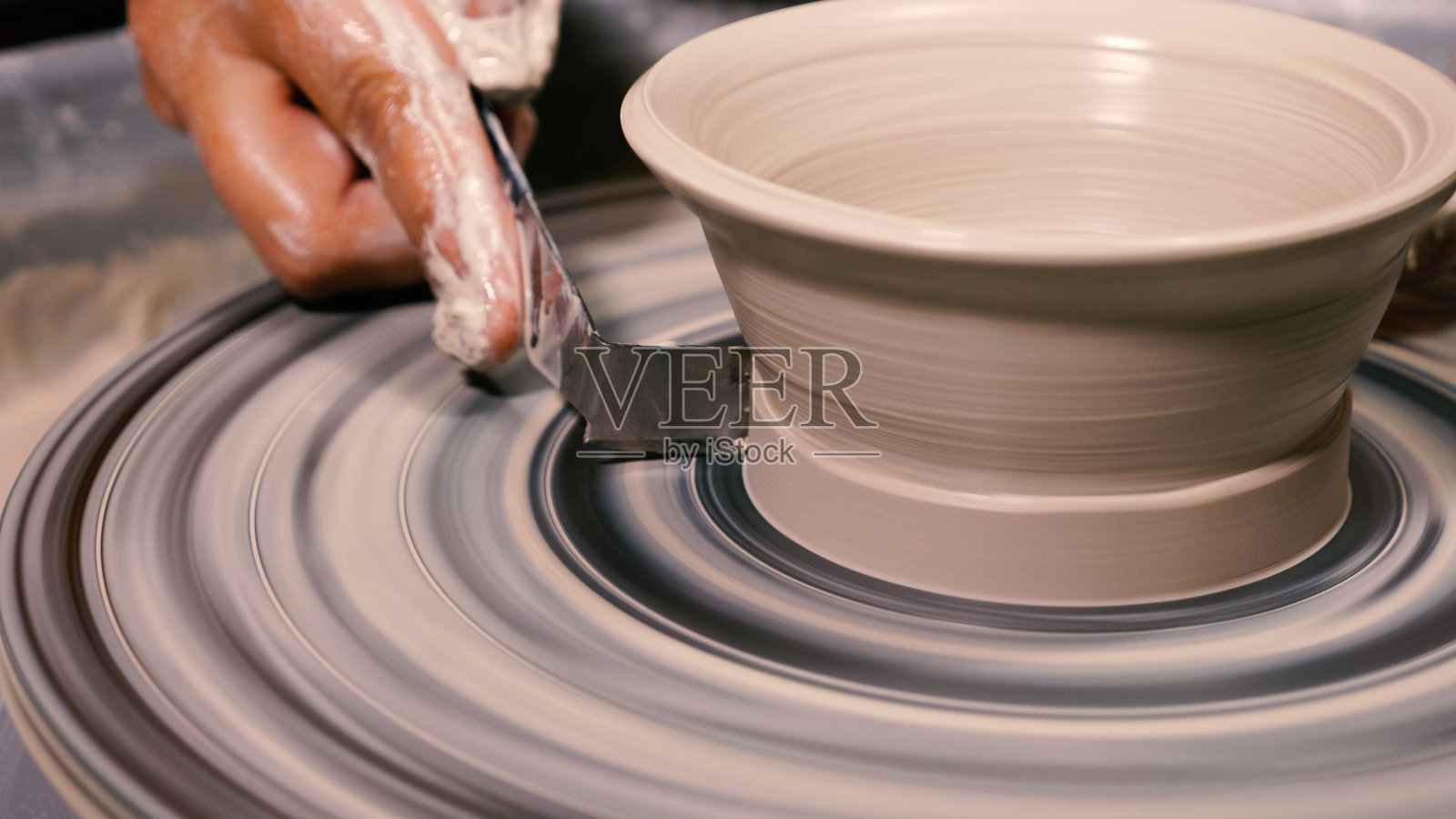 陶工用的刮泥器,用来清除成品上多余的粘土。在陶艺作坊里做陶工的转盘照片摄影图片