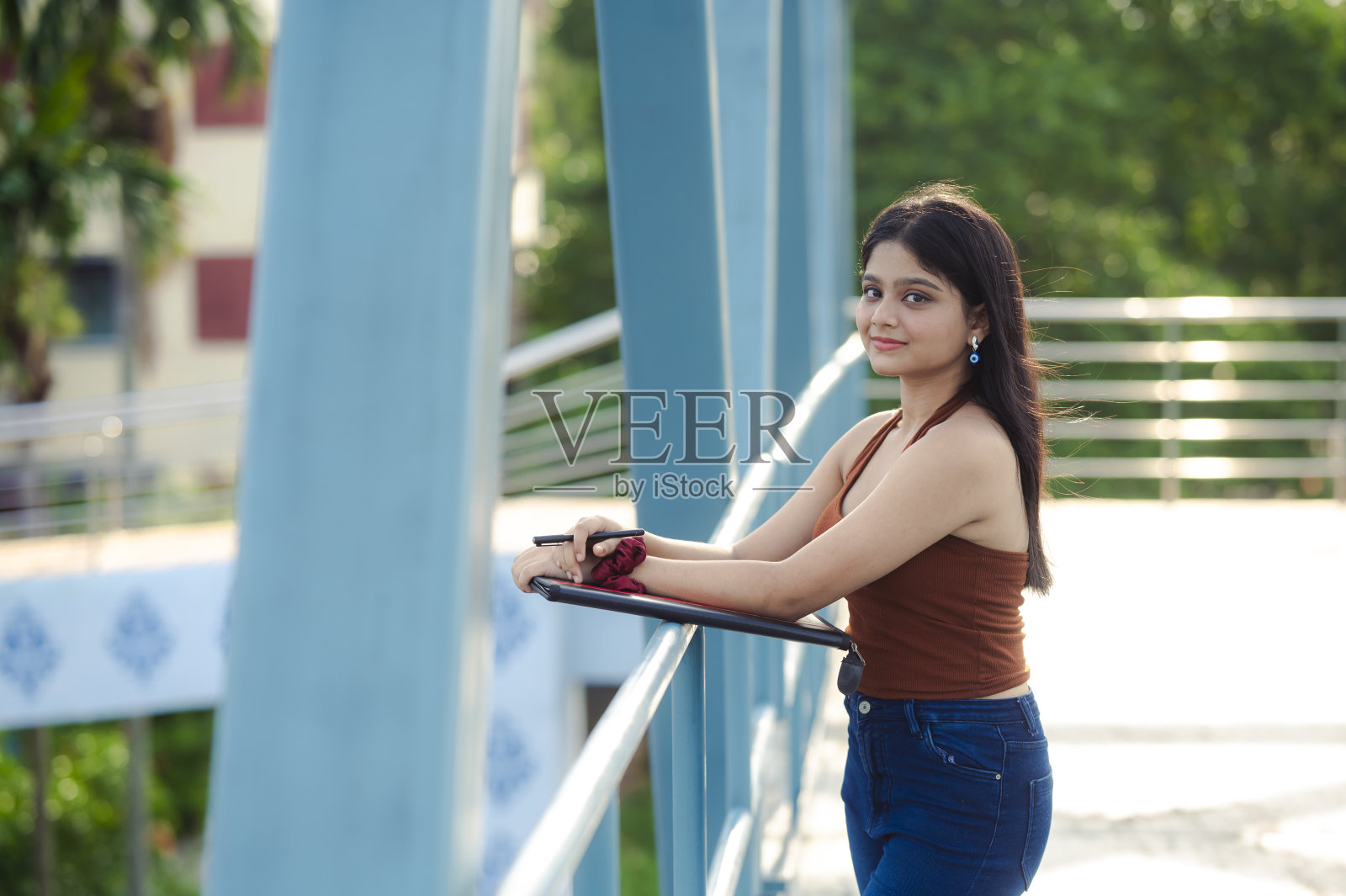 年轻美丽的印度学生肖像与学习材料照片摄影图片