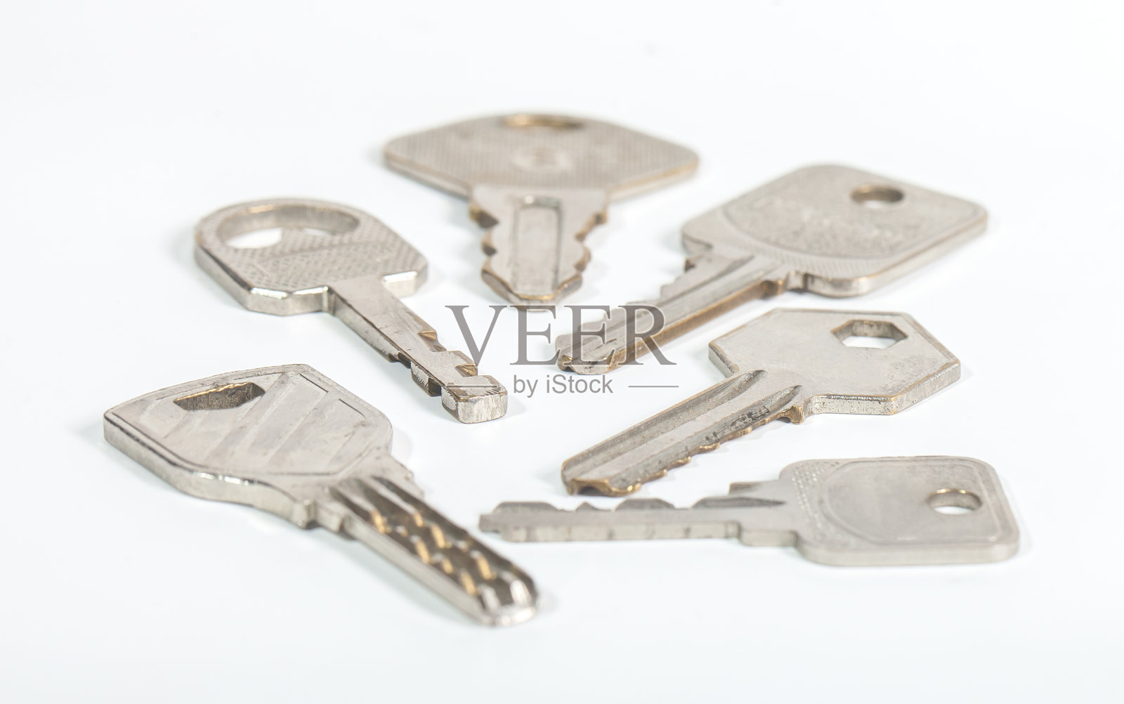 一套由金属制成的房门钥匙,它们被隔离在白色的背景上照片摄影图片