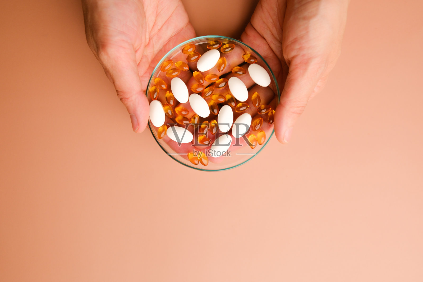 手里拿的是胶囊凝胶和白色维生素片,带有复制空间的天然维生素和补充概念。照片摄影图片