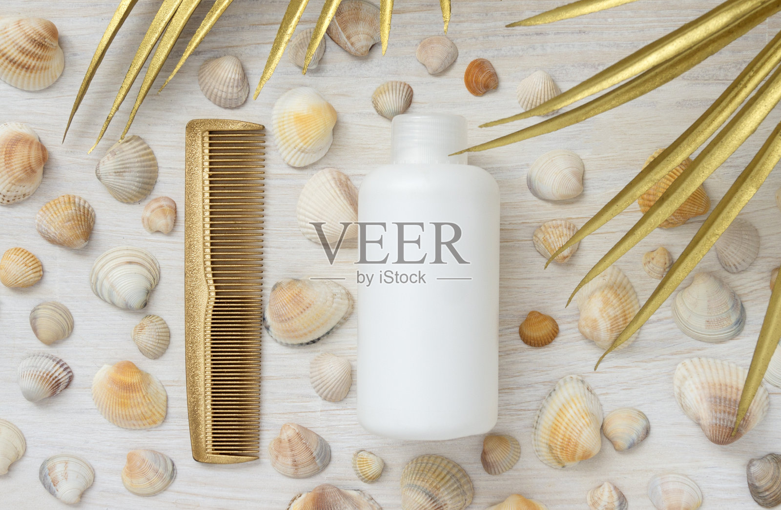 白色塑料瓶没有铭文头发梳夏季背景与贝壳和金色棕榈叶。夏季护发产品模型。照片摄影图片