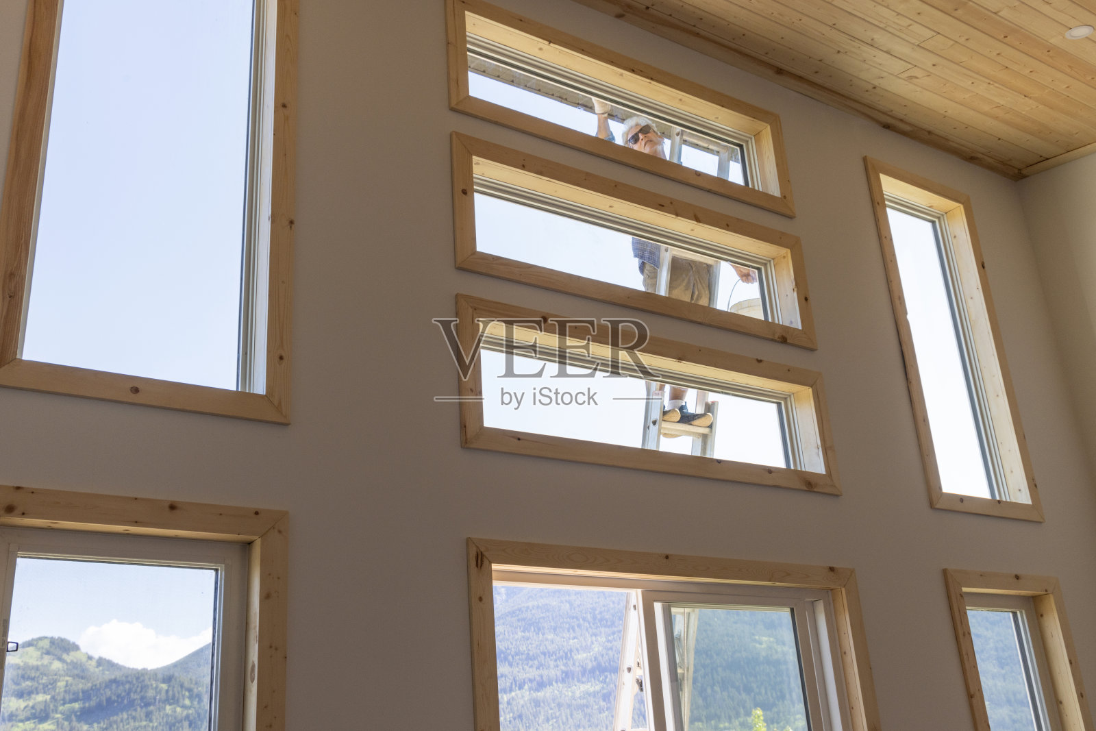 老人粉刷房屋外墙照片摄影图片