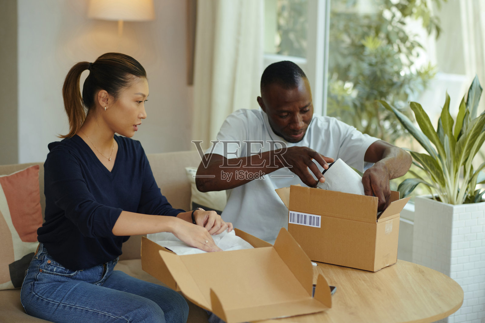 夫妇打开装有货物的箱子照片摄影图片