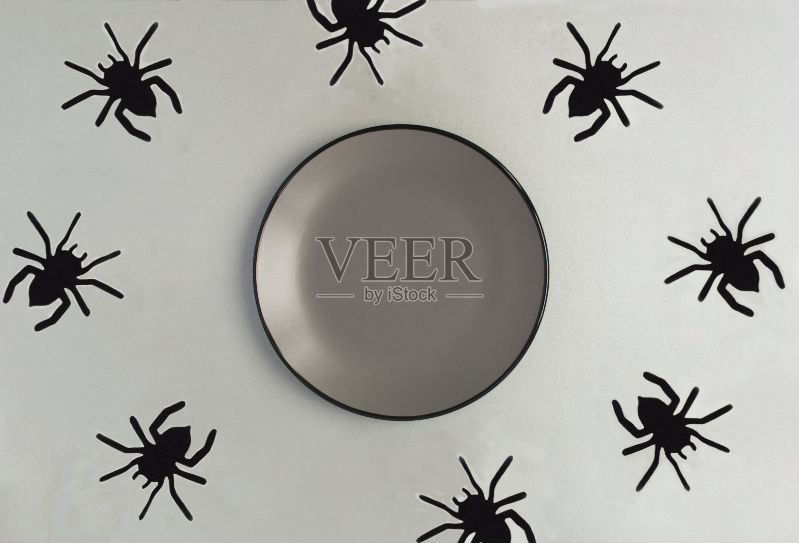 万圣节的背景。空白灰色板的文字和装饰黑色蜘蛛在灰色背景。前视图。照片摄影图片